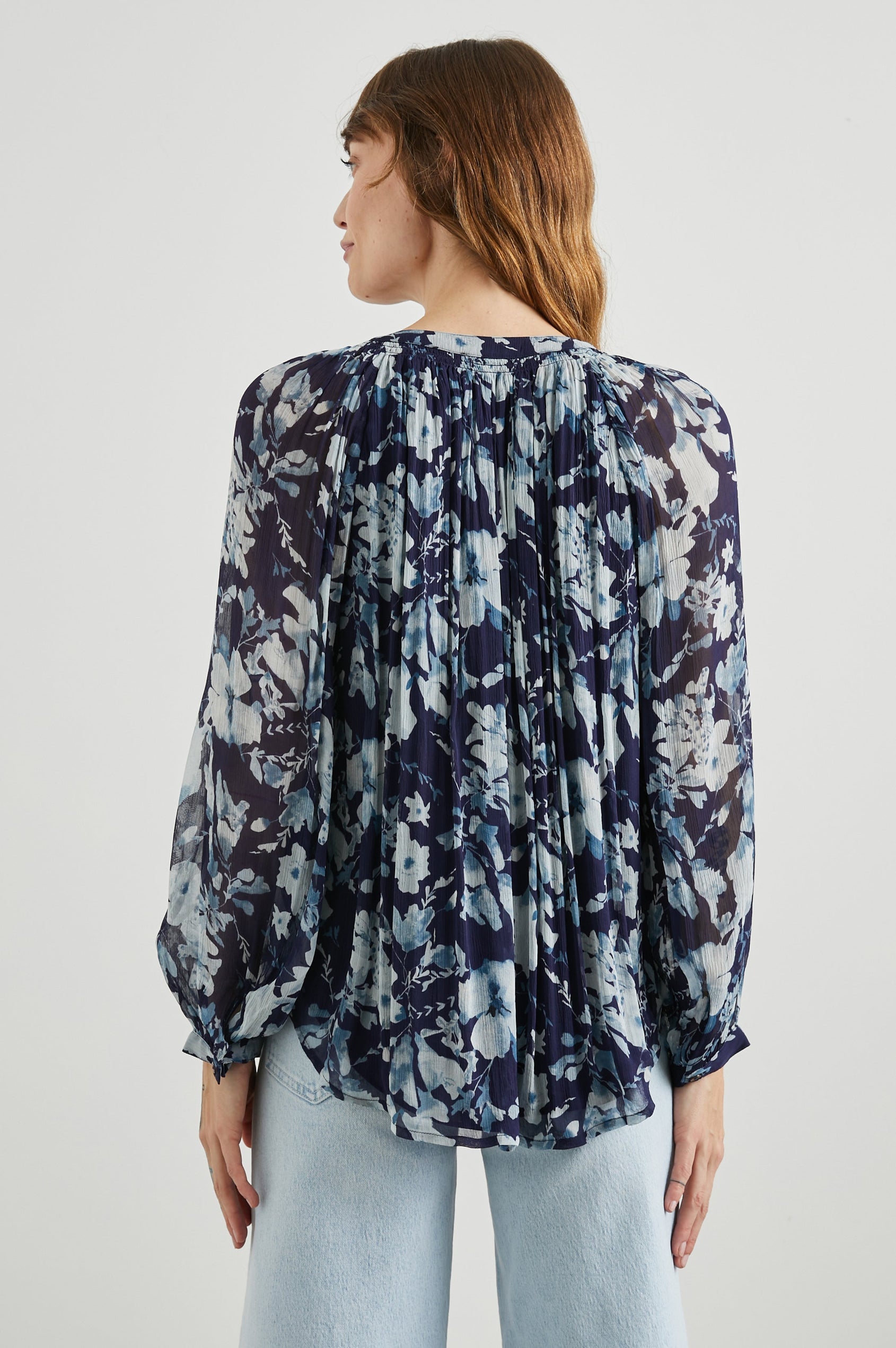Nessie Long Sleeve Top with Front Button Closure and Ruching along the Neckline in Indigo Blossoms Colorway, Flowers in Blue on Indigo - Back View Featured on Model 