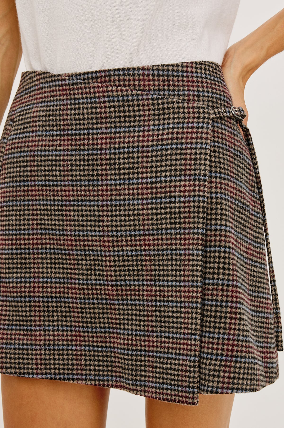 Nial Mini Skirt in Wool Blend With Wrap Front, Buckled Side Strap, Side Welt Pocket, Seam Zip Closure, and Fully Lined in Oxford Plum Colorway - Lower Body Close Up View Featured on Model