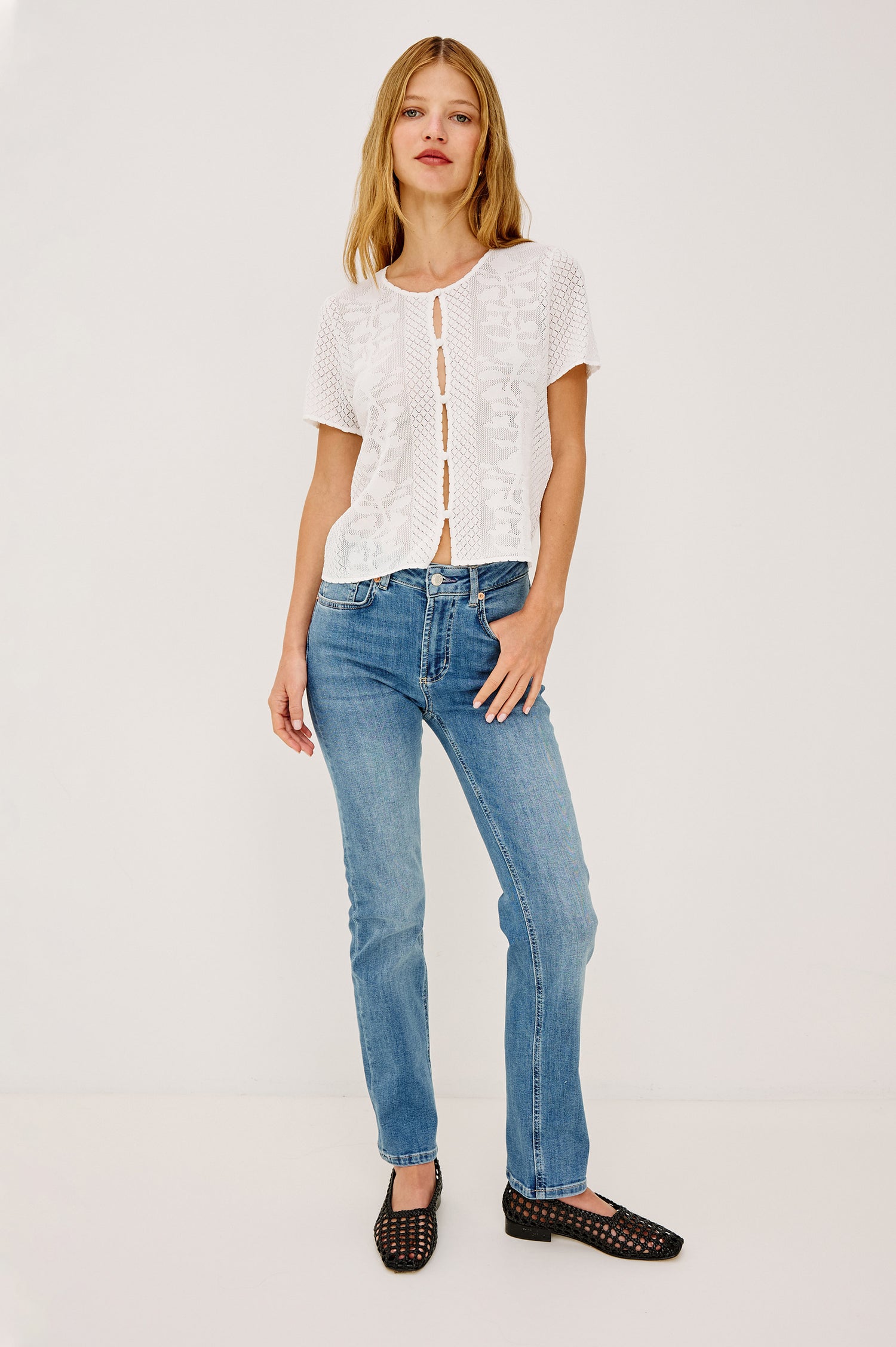 Nina Top in Sheer Netted Lace With Scoop Neckline, Front Cutouts With Self-Covered Buttons, Short Sleeves, and a Boxy, Cropped Silhouette in Ivory Colorway - Full Body Front View Featured on Model