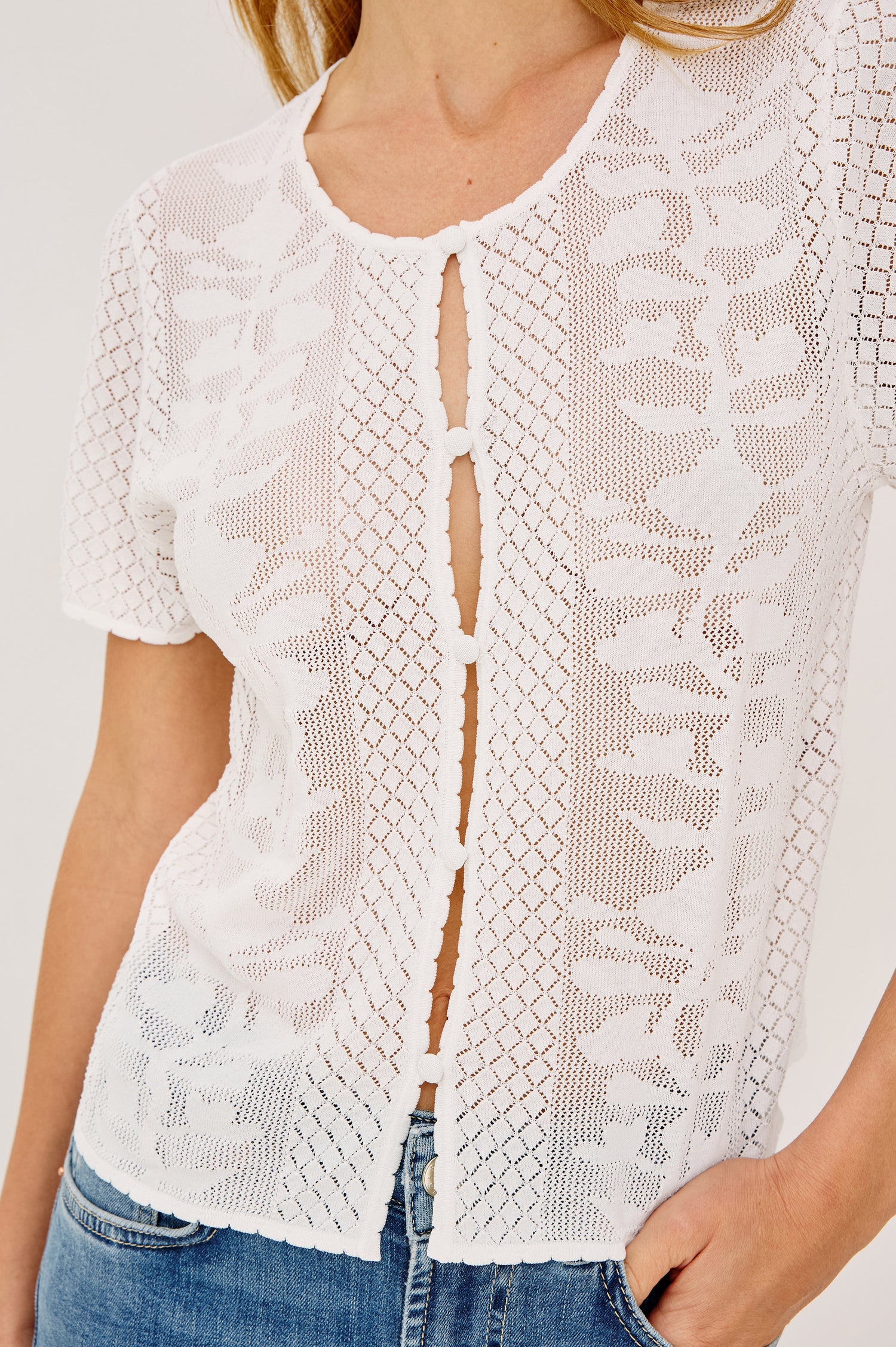 Nina Top in Sheer Netted Lace With Scoop Neckline, Front Cutouts With Self-Covered Buttons, Short Sleeves, and a Boxy, Cropped Silhouette in Ivory Colorway - Upper Body Front View Featured on Model