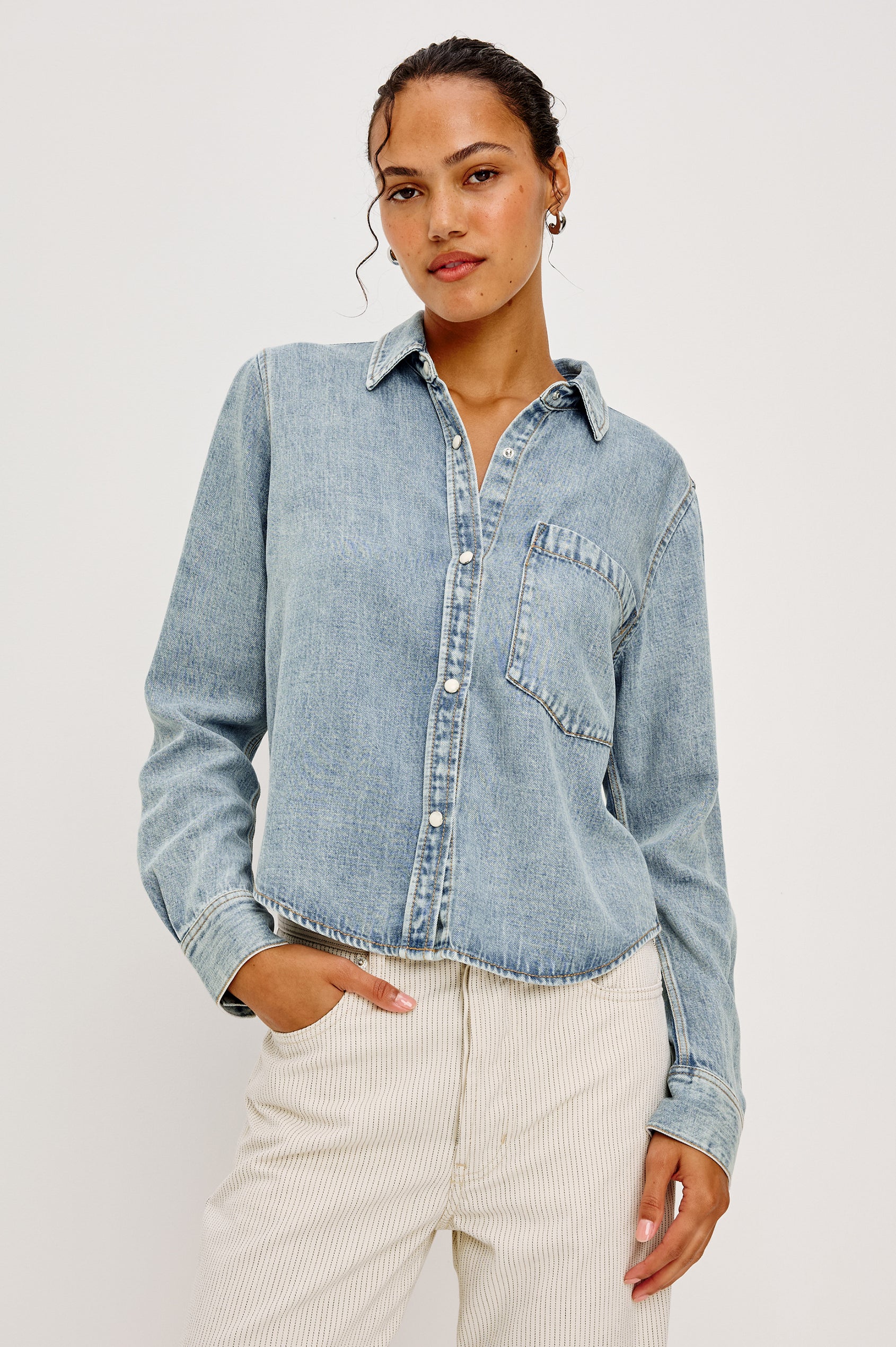 Noa Button-Up Shirt in Denim With Collar Front Buttons Single Chest Patch Pocket and Boxy Fit in Faded Indigo Colorway - Upper Body Front View Featured on Model