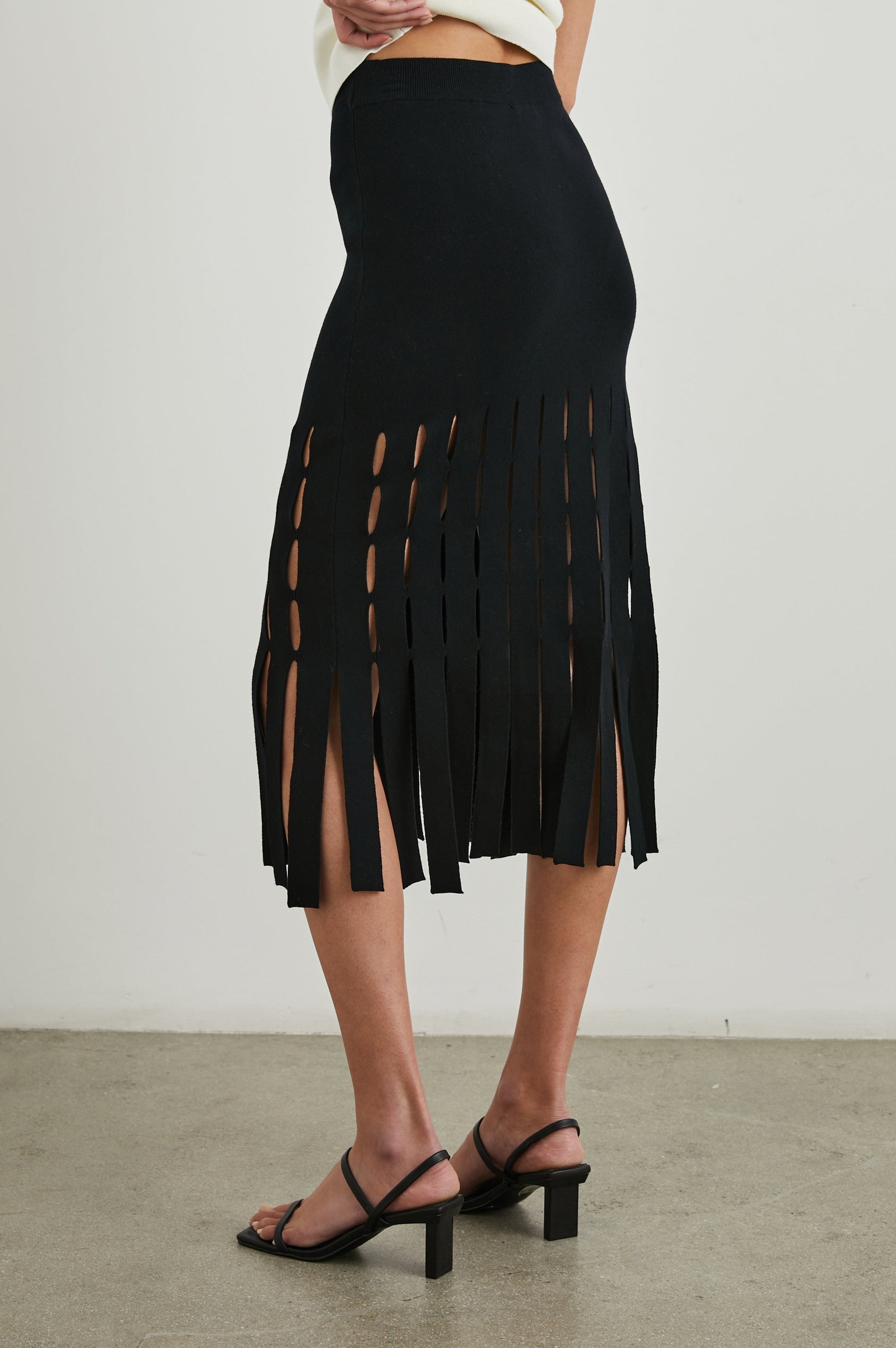 Nola Midi Skirt with Cutouts from the Mid-Thigh Down and Ending in Cut Panels in Black Colorway - Back View Featured on Model 