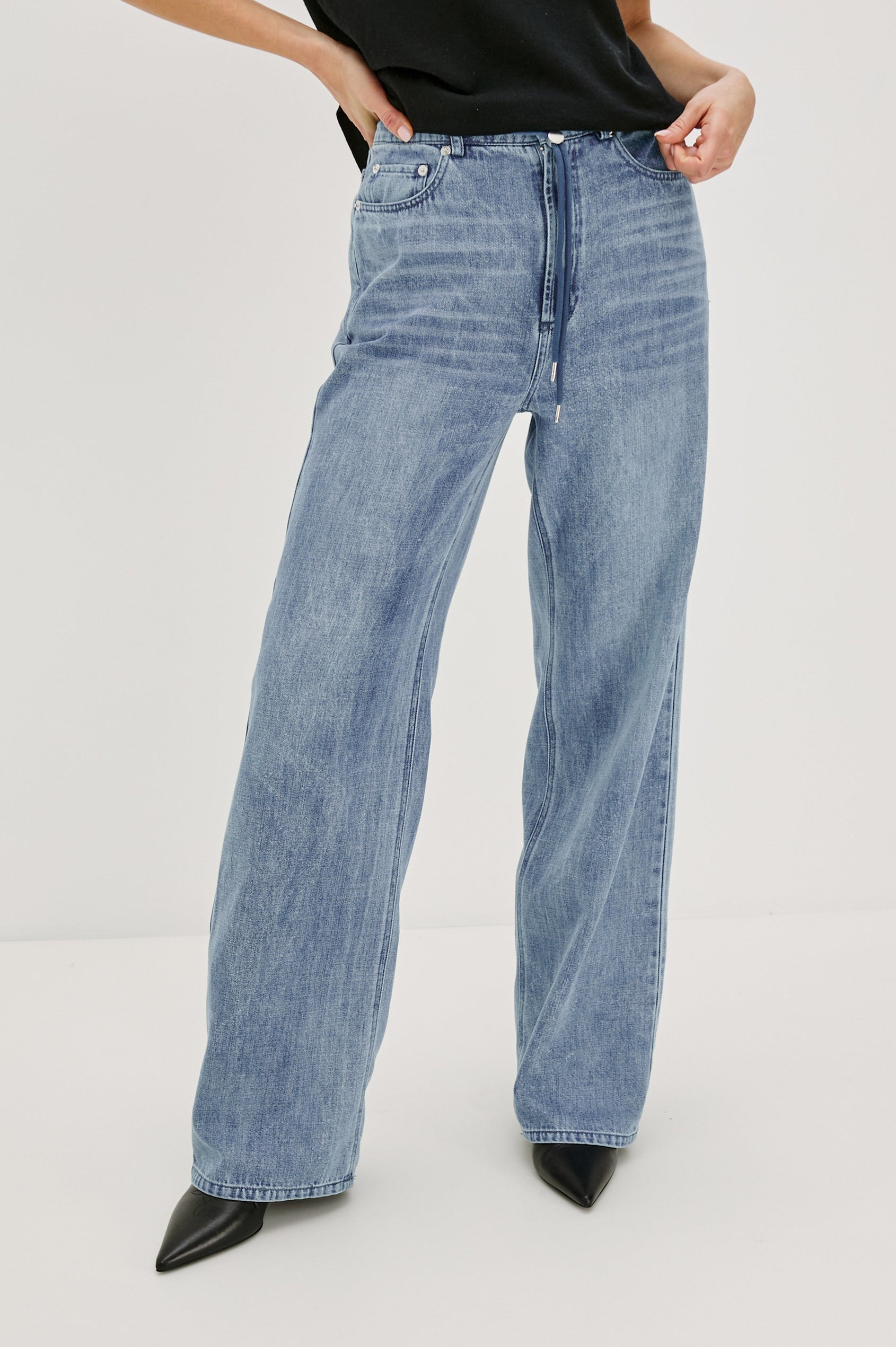 Normandie Lightweight 5-Pocket Denim Wide Leg Pant with front zipper button fly and a drawstring tie at waist in Antique Blue Colorway. Front View Featured on Model.
