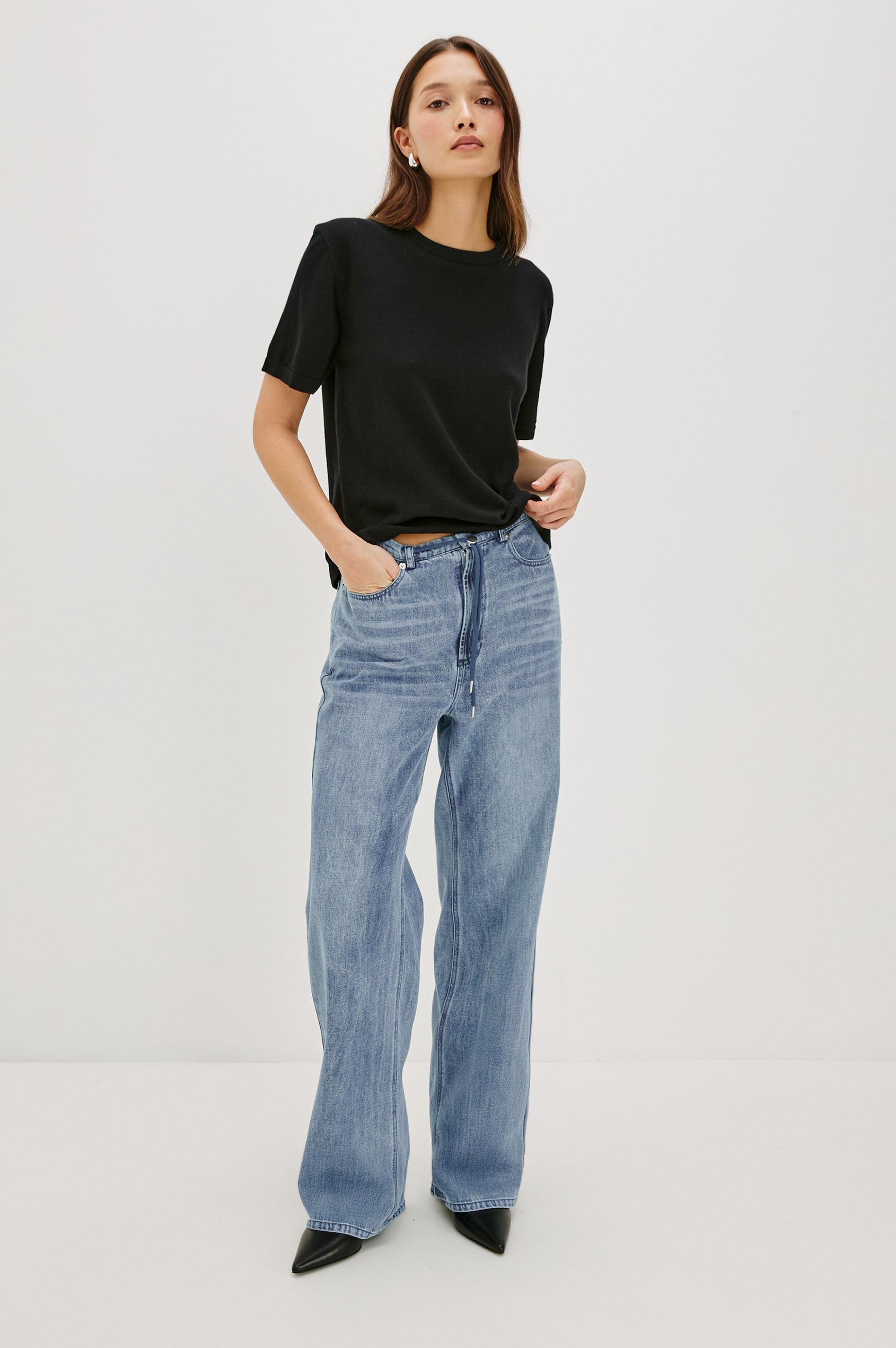 Normandie Lightweight 5-Pocket Denim Wide Leg Pant with front zipper button fly and a drawstring tie at waist in Antique Blue Colorway. Full Body Front View Featured on Model.