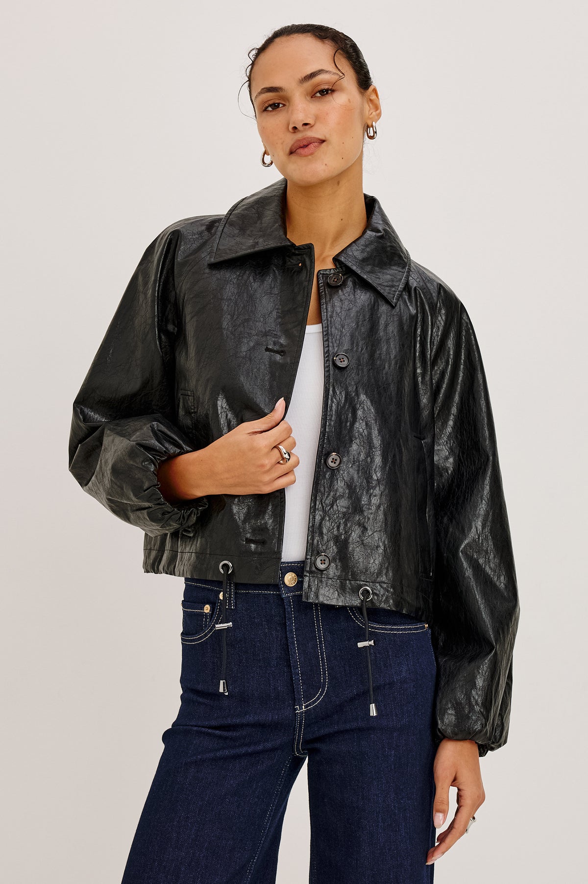 North Jacket in Vegan Leather With Cropped, Boxy Fit, Drawcord Hem, Oversized Collar, Front Buttons, and Welt Pockets in Black Colorway - Front View Featured on Model.