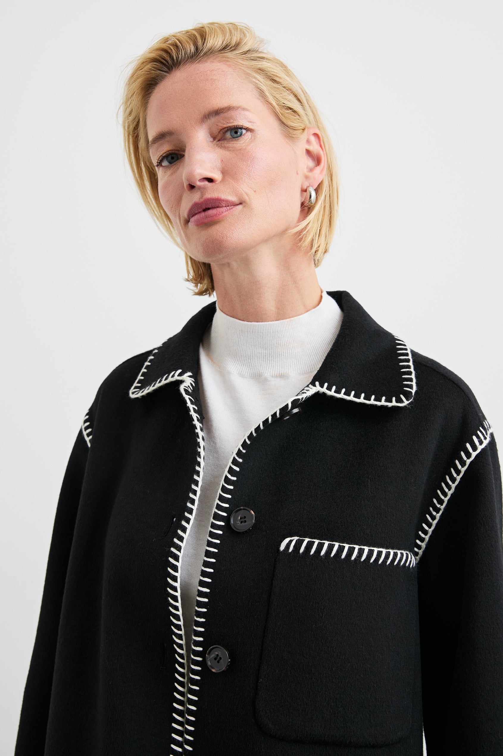 Odyssey Jacket with Four Button Closure and a Chest Patch Pocket in Black Colorway, with white contrast stitching - Front View Featured on Model