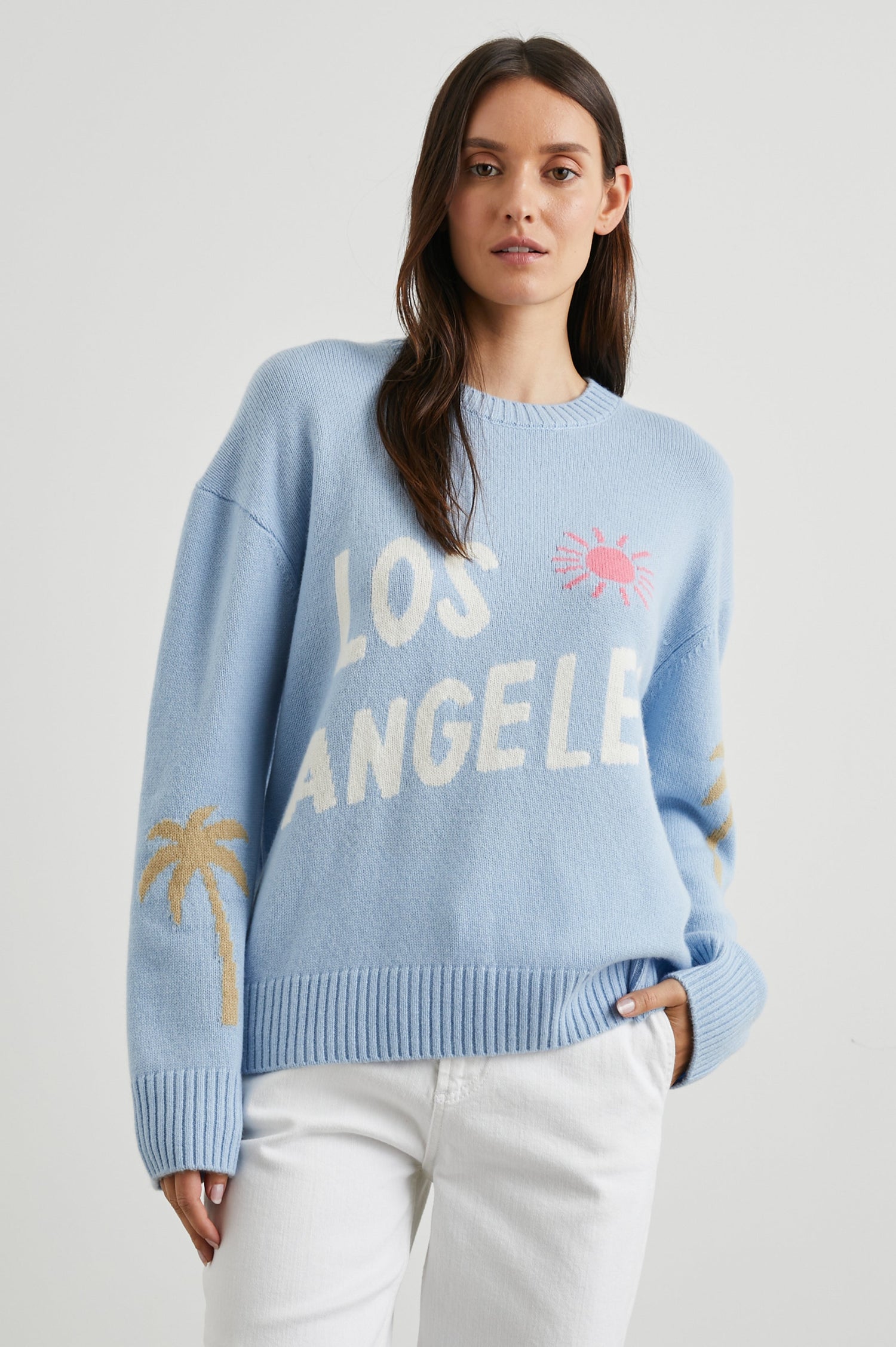 Olivia Long-Sleeve Sweater with a Crew Neck, a Pink Sun and Gold Palm Trees and the White Text, Los Angeles, in Los Angeles Blue Colorway - Front View Featured on Model  