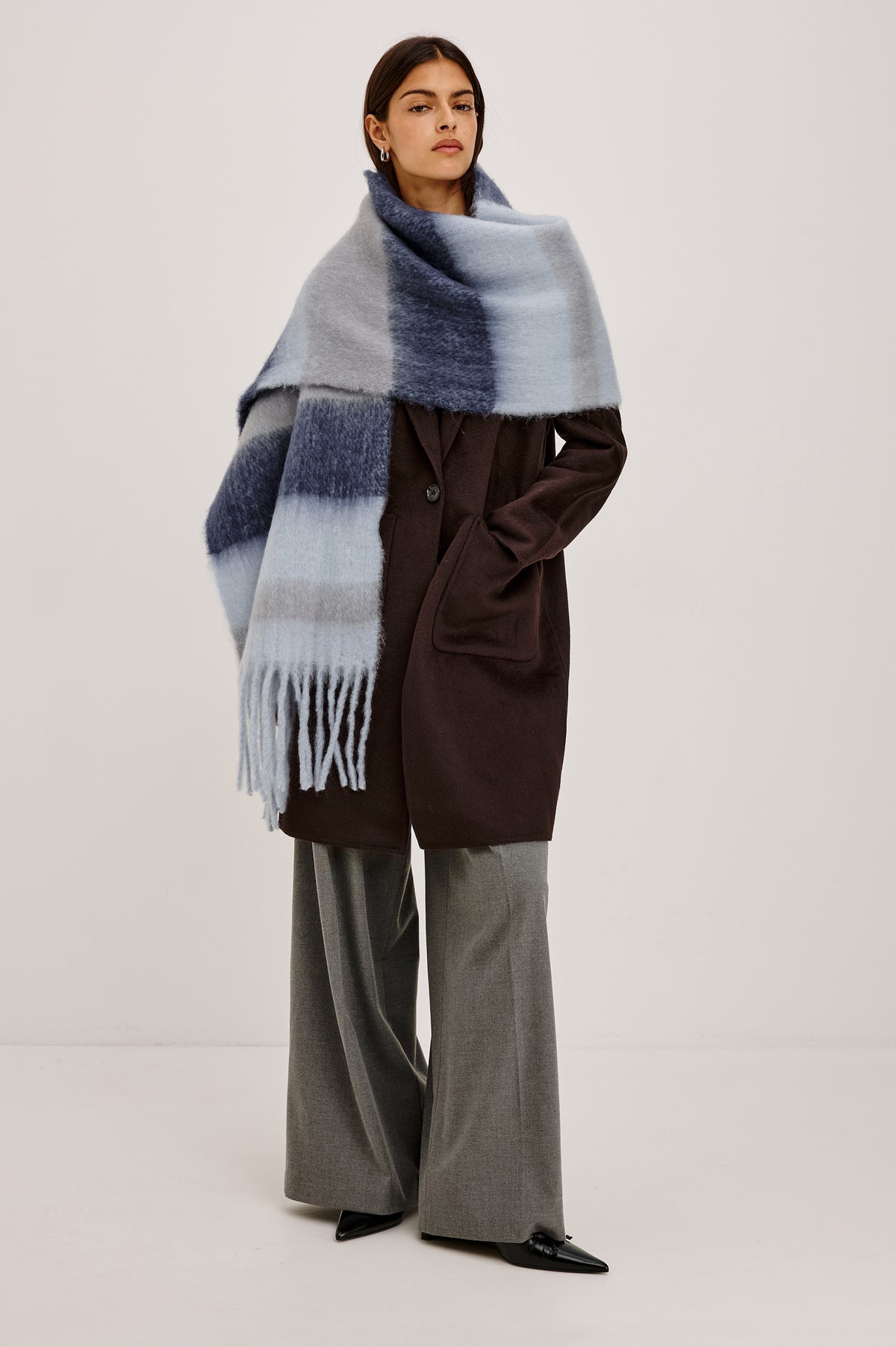 Oslo Scarf in Brushed Polyester Knit With Oversized Shape and Fringe Trim in Sky Indigo Stripe Colorway - Full Body Front View Featured on Model.