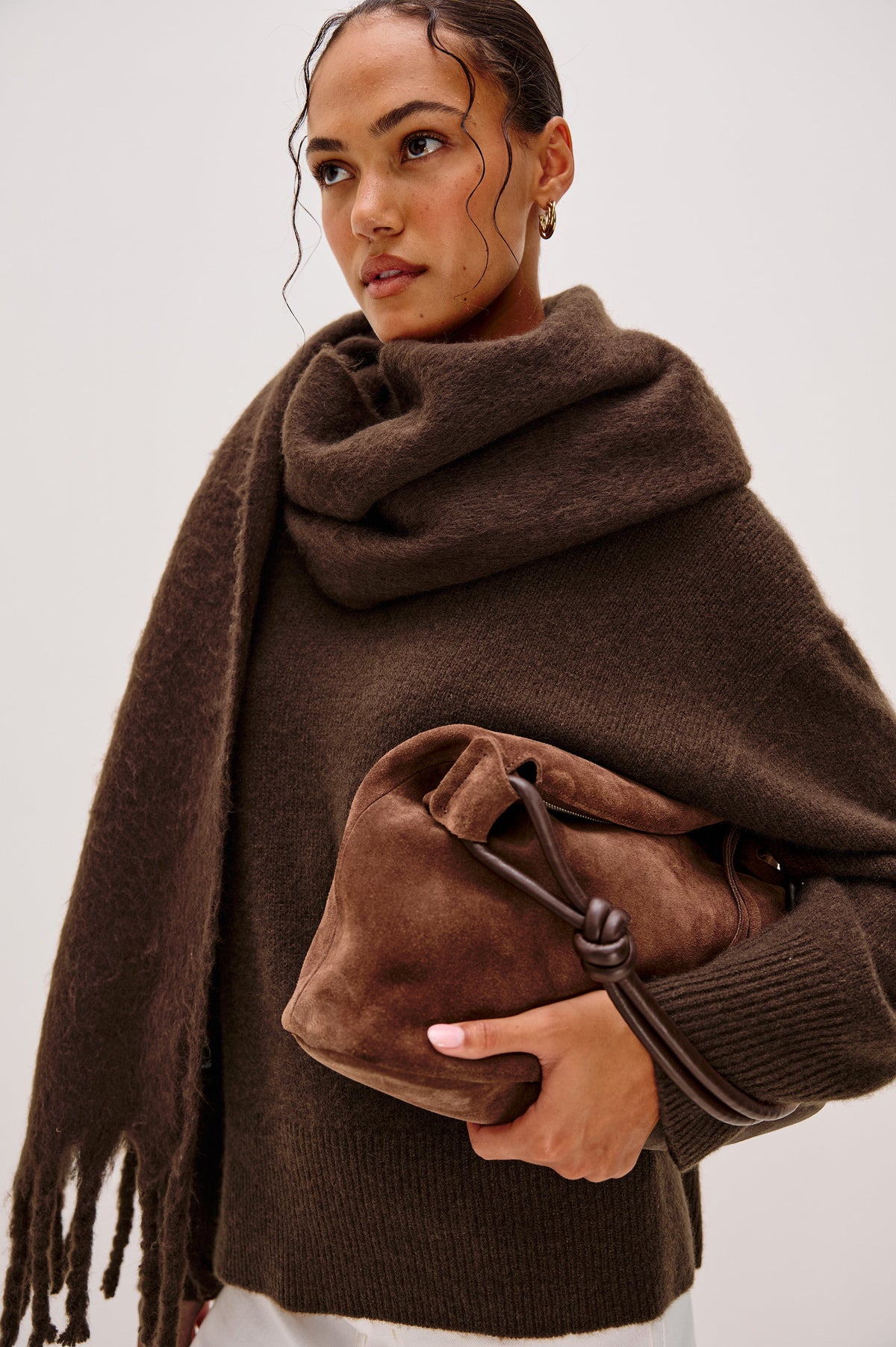 Oslo brown scarf is incredibly soft with beautiful drape and stretch that features playful fringe trim and endless styling possibilities. Front view of model feautured.