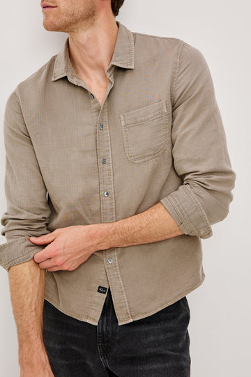 Owens is a long sleeve, collared, button front shirt in lightweight cotton, long sleeve, and features a subtle pattern variation on the backside of the fabric in Desert Path colorway. Front detail view featured on model.
