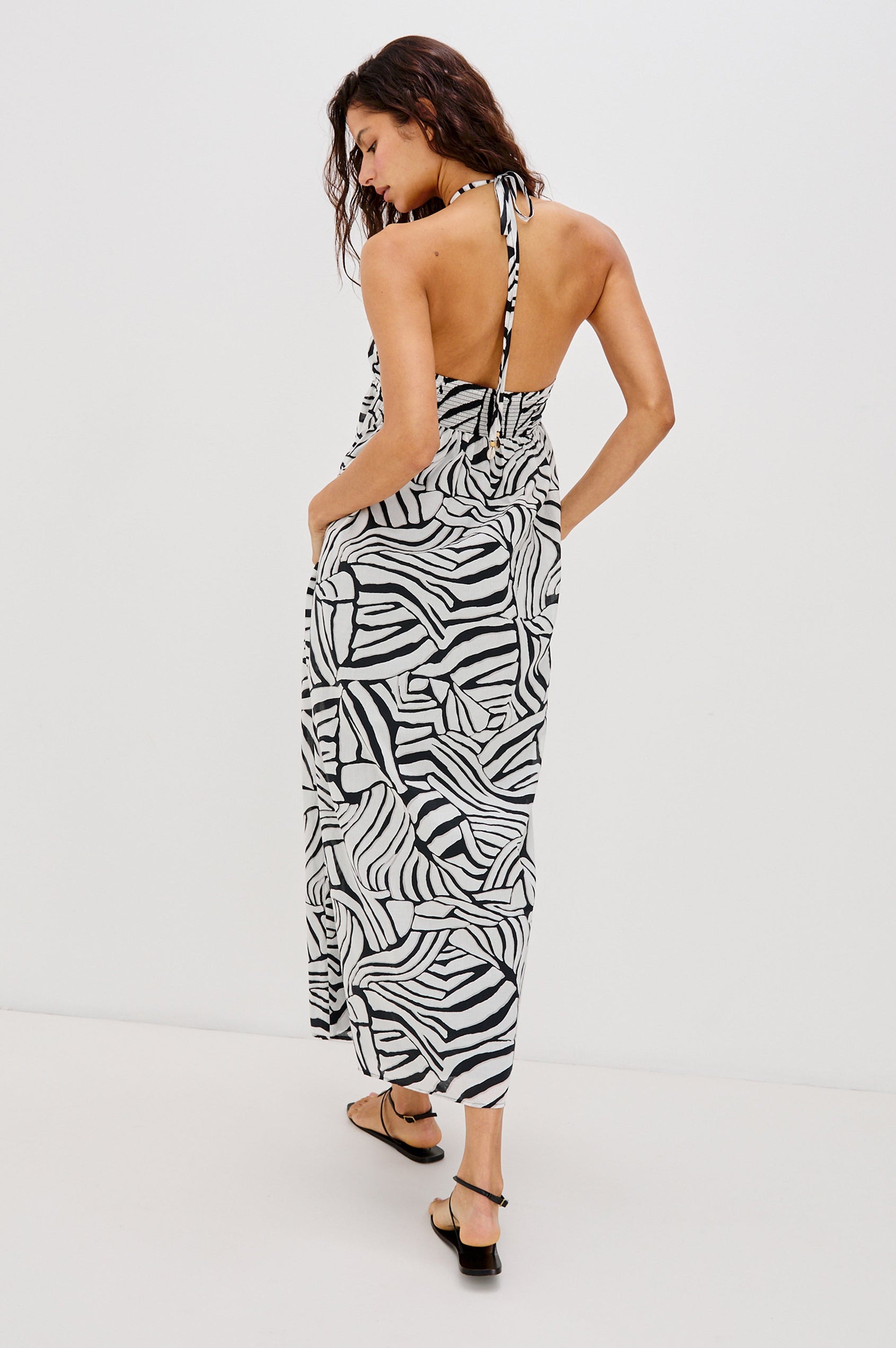 Palazzo Halter Midi Length Dress with Tie Neck and Sea Shell Lattice Detail at Center Front in White and Black Abstract Playa Blanco Colorway. Full Body Back View Shown on Model.
