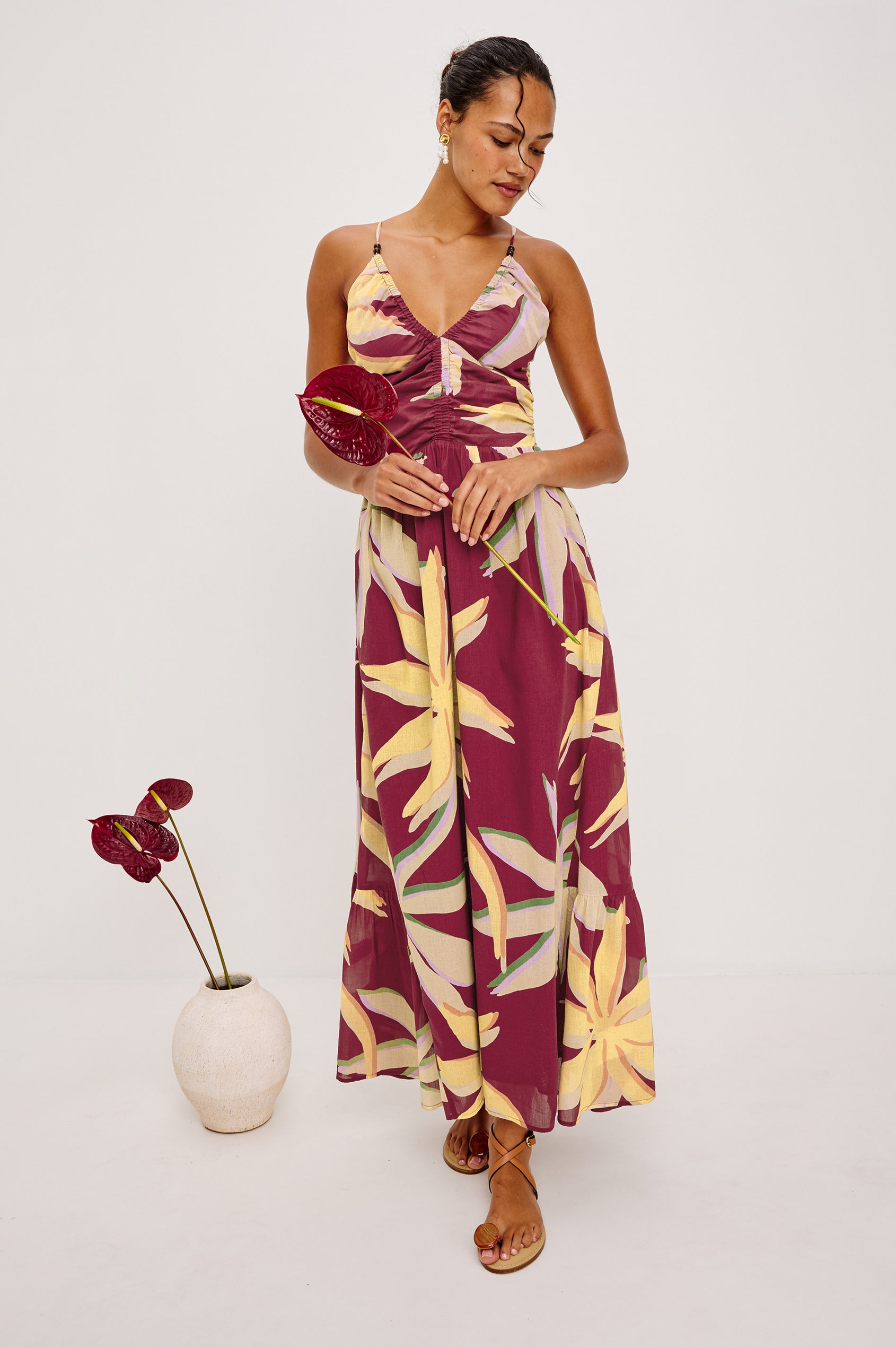 Palm Maxi Dress in Beach Cotton WIth Fitted Shirred Bodice V-Neckline Adjustable Shoulder Straps With Wooden Bead Detailing and Tiered Skirt in Red Palma Colorway - Full Body Front View Featured on Model