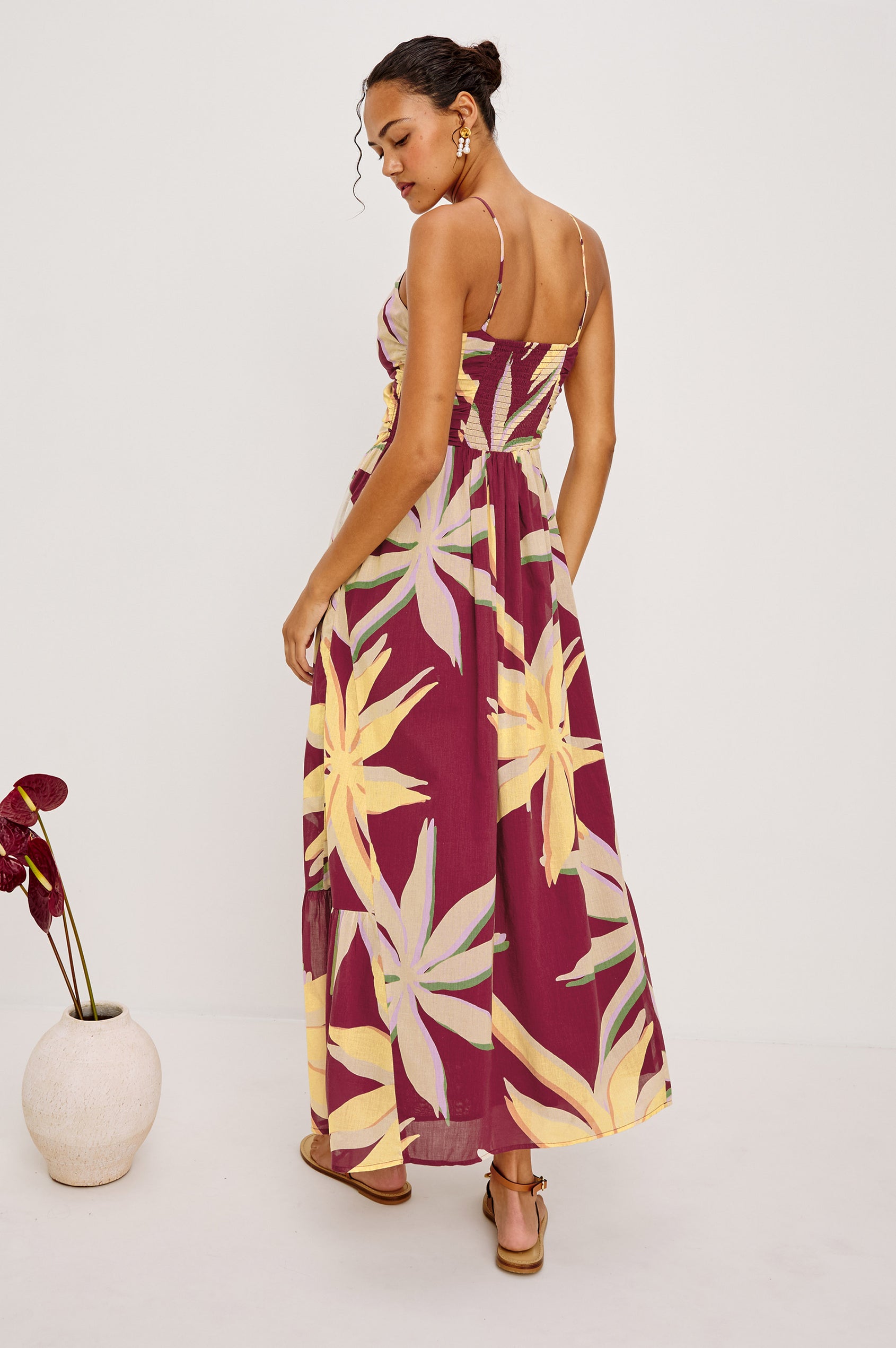 Palm Maxi Dress in Beach Cotton WIth Fitted Shirred Bodice V-Neckline Adjustable Shoulder Straps With Wooden Bead Detailing and Tiered Skirt in Red Palma Colorway - Full Body Back View Featured on Model