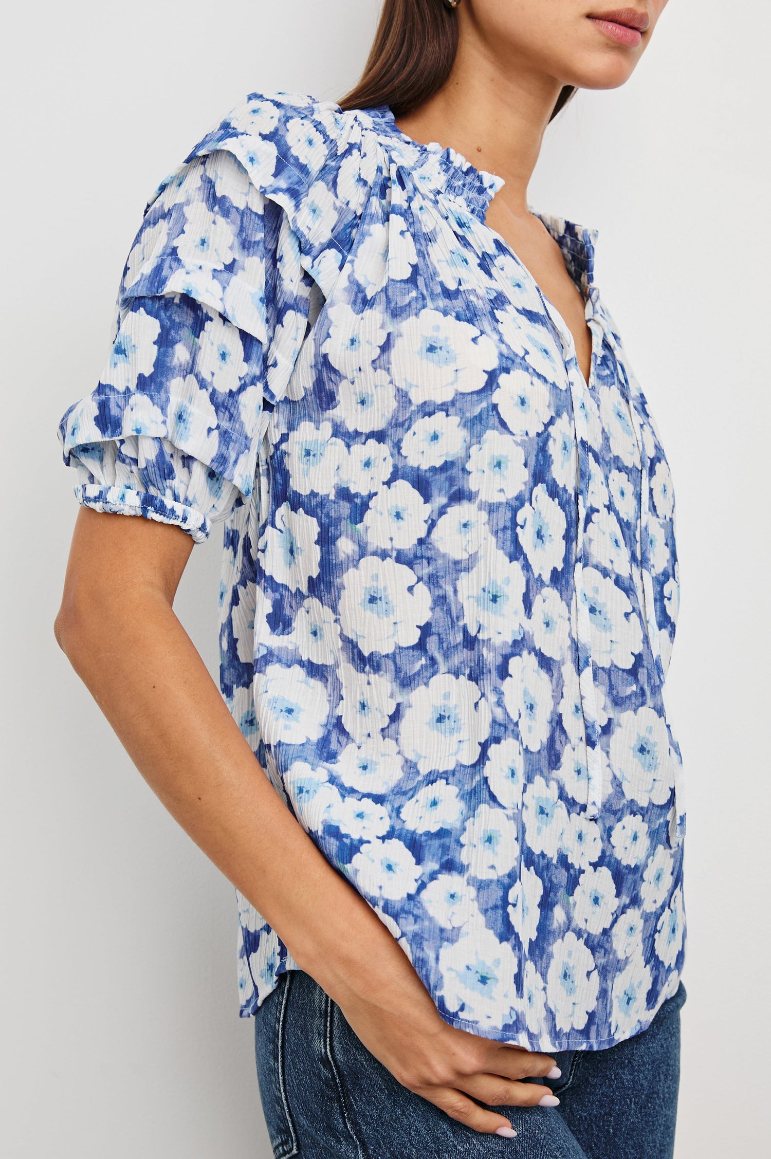 Paris Short-Sleeve Top with Shirred Collar, V-neckline with Ties, Deep Pleats on Sleeves and Elastic at the Sleeve Opening in Blue Floral Colorway, Blues and White - Front Untucked View Featured on Model