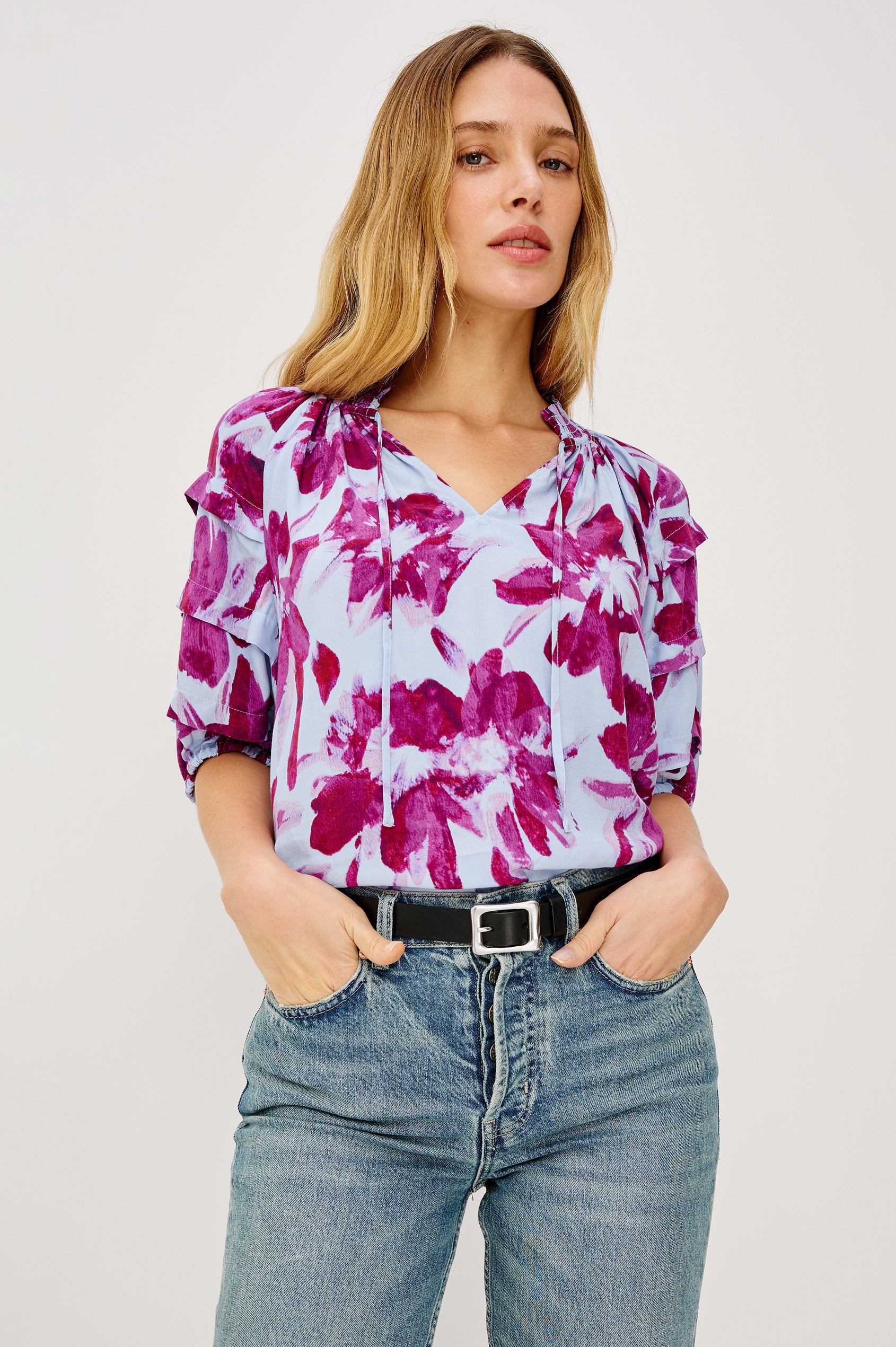 Paris Short-Sleeve Top with Shirred Collar, V-neckline with Ties, Deep Pleats on Sleeves and Elastic at the Sleeve Opening in Blue Lily Colorway, Blues and Pink- Front Tucked View Featured on Model