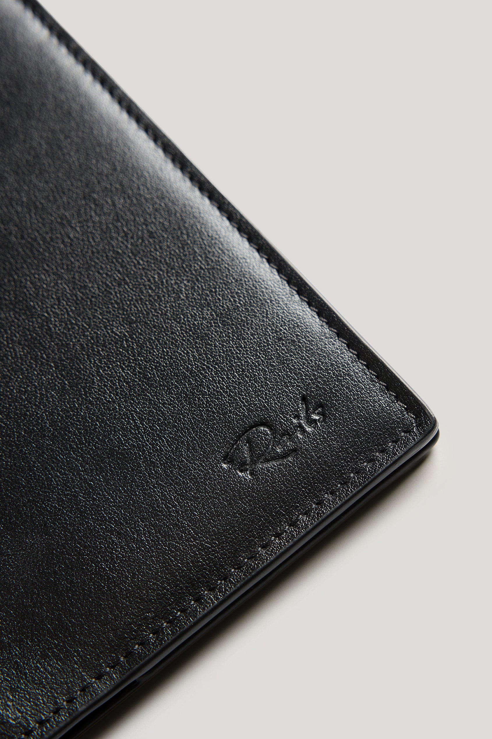 Leather passport holder opened, close up inside view, in Black colorway.