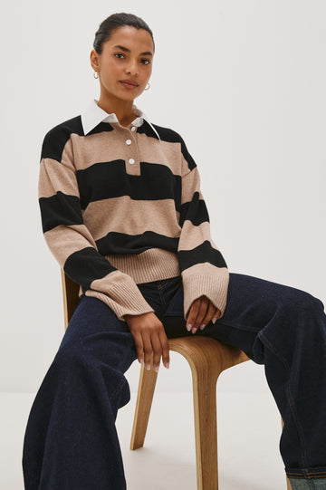 Cotton-cashmere henley sweater with relaxed fit. Design features black heritage-style stripes and a contrasting white cotton poplin collar. Front view on model sitting in a chair.