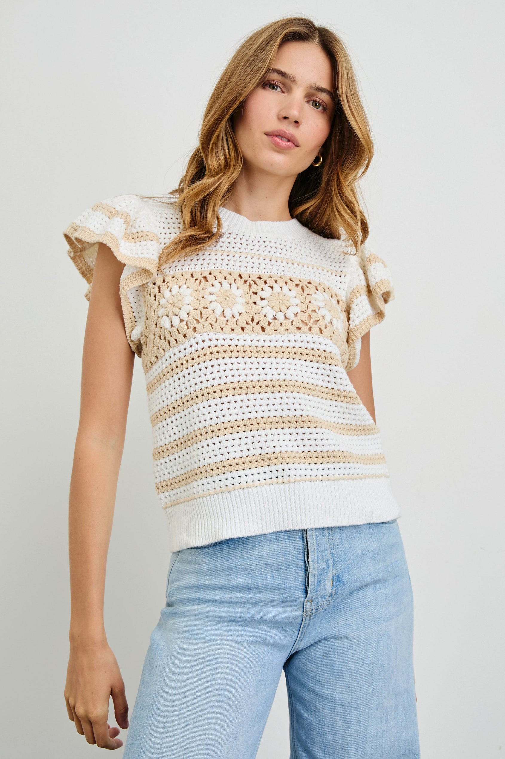 Penelope Crochet Top with Flutter Sleeves and Ribbed Hem in Ivory Oat Crochet Stripe Colorway, with contrasting knit flowers across the chest - Front View Featured on Model