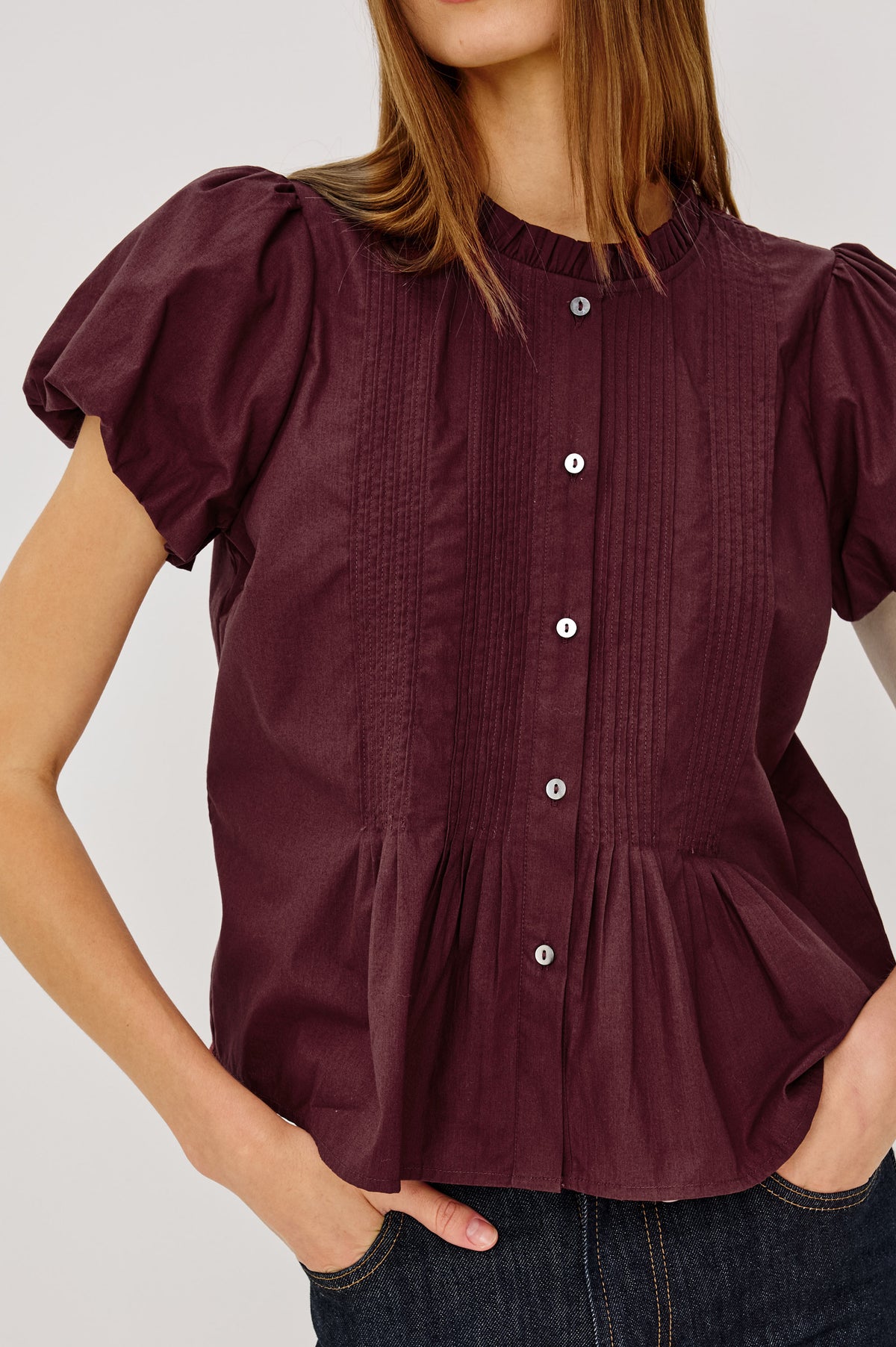 Pepper Shirt in Cotton Poplin With Loose Boxy Fit, Pintuck Detailing, Puff Cap Sleeves, Center-Front Buttons, and Soft Peplum Hem in Port Colorway - Upper Body Front View Featured on Model