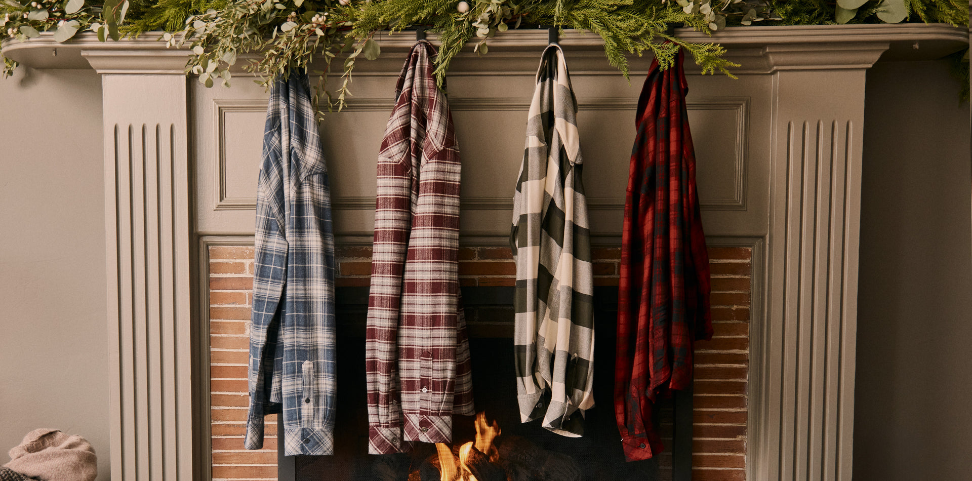 EDITORIAL IMAGE OF MULTIPLE PLAID SHIRTS HANGING ON FIREPLACE
