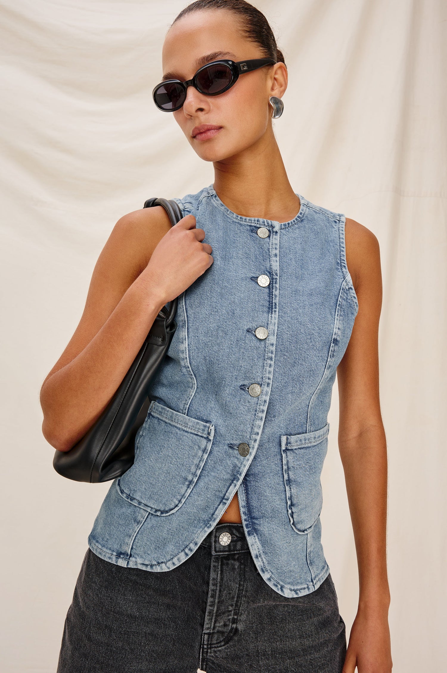 Portola Sleeveless Denim Vest with Exposed Button Front Closure, Crew Neck, Front Patch Pockets and a Scalloped Split Hem in Blue Eyed Girl Colorway. Full Body Front View Shown on Model.