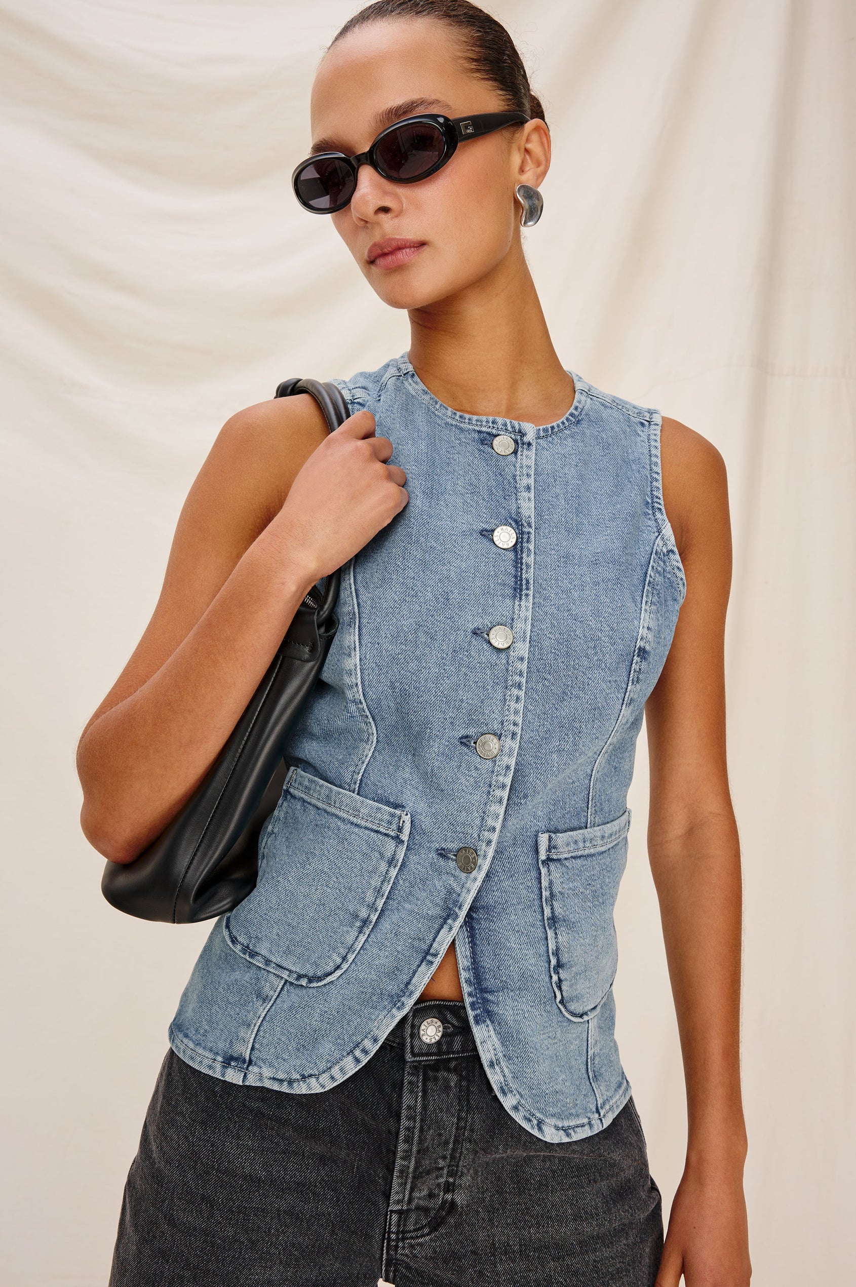 Portola Sleeveless Denim Vest with Exposed Button Front Closure, Crew Neck, Front Patch Pockets and a Scalloped Split Hem in Blue Eyed Girl Colorway. Full Body Front View Shown on Model.