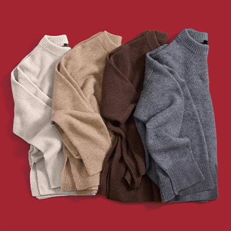 Four oversized knit sweaters in cream, camel, brown, and gray, arranged side by side on a red background.