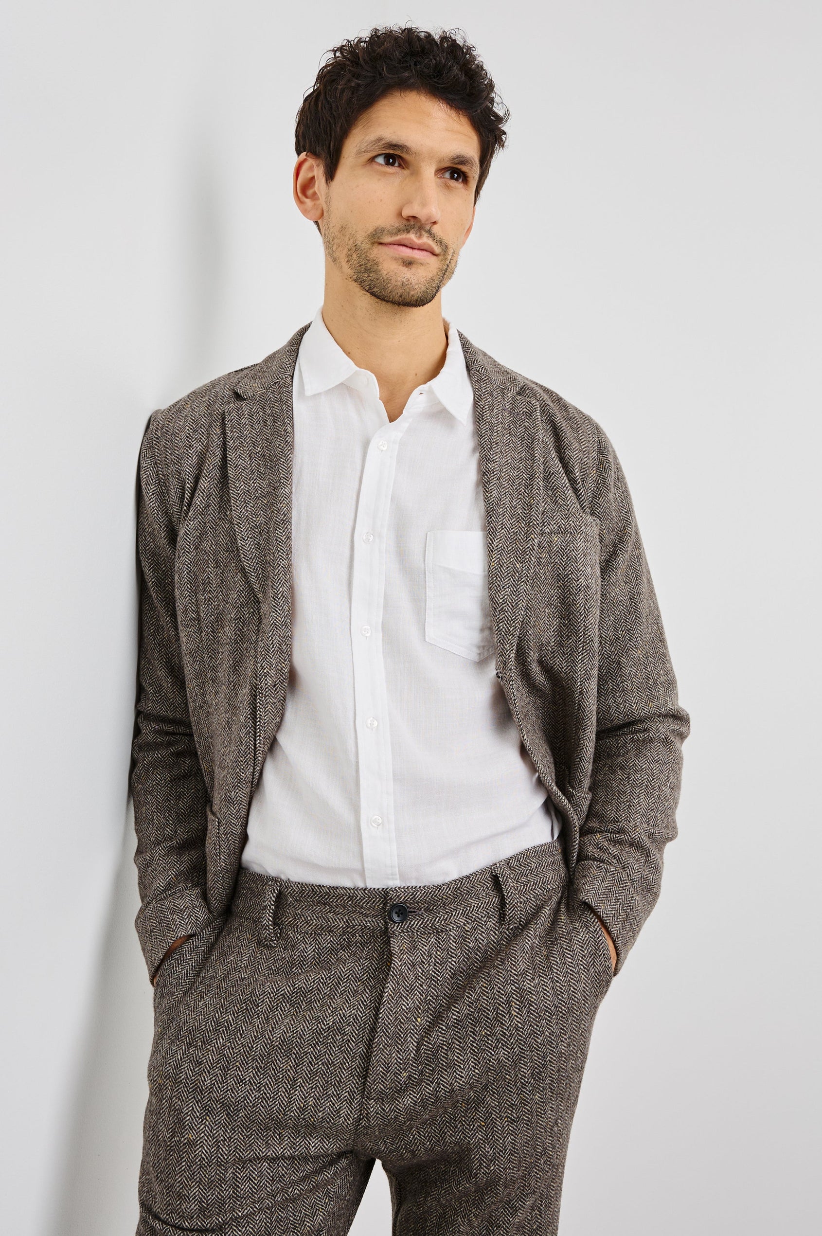 Reynard Blazer with Two Button Closure, Two Front Pockets, a Chest Welt Pocket, Herringbone Fabric in Highland Tweed Colorway, a Brown - Front View Featured on Model