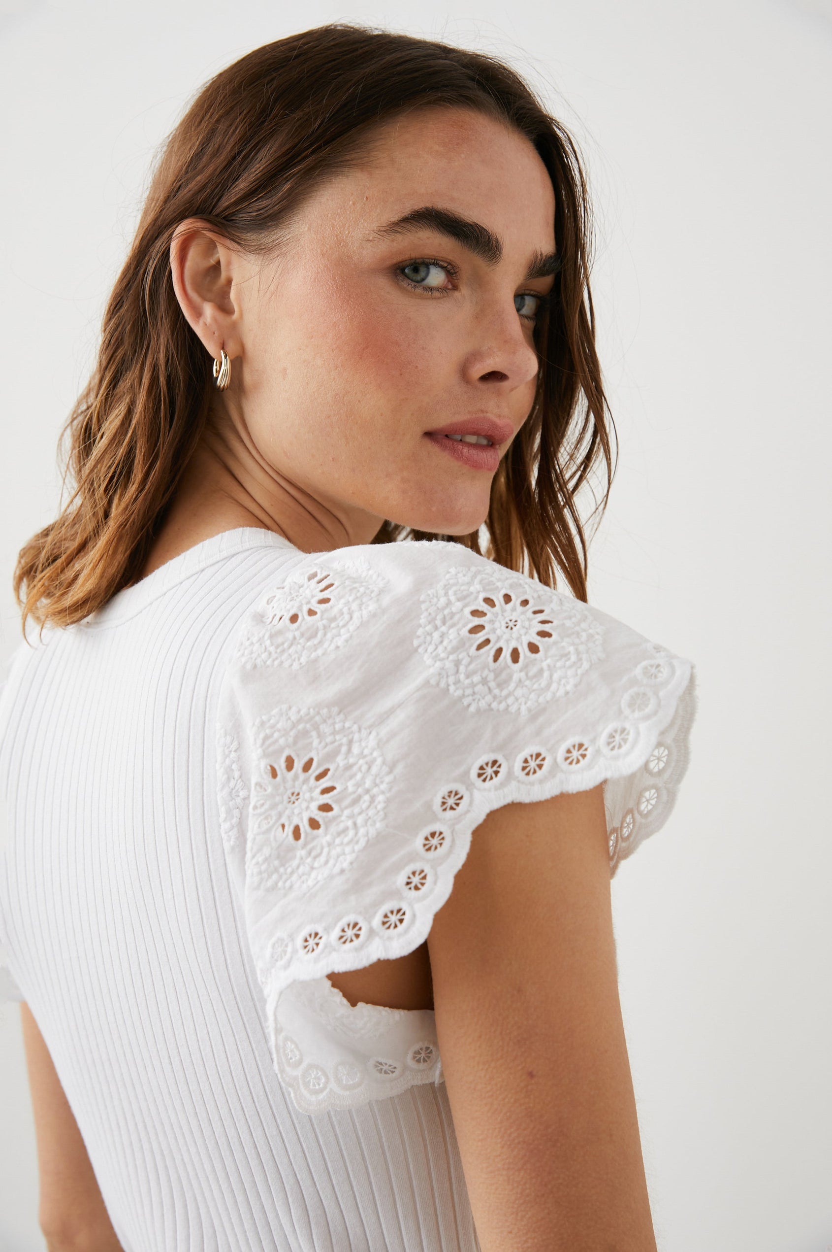Reza Ribbed Short Sleeve Top with Flutter Sleeves, a Crew Neck and Floral Eyelets on the Sleeves in White Colorway - Back View Featured on Model 