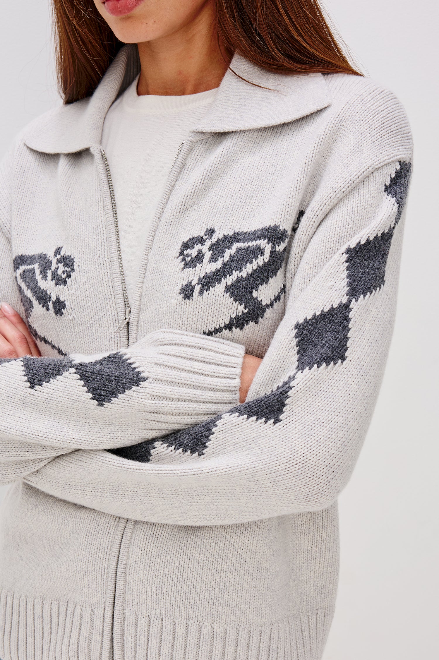 Rhea Longline Cardigan in Wool Blend With Skier Motifs, Stand Collar, Diamond Detailing at Long Sleeves, Relaxed Fit, and Front Zipper in Powder Grey Colorway - Upper Body Close Up View Featured on Model