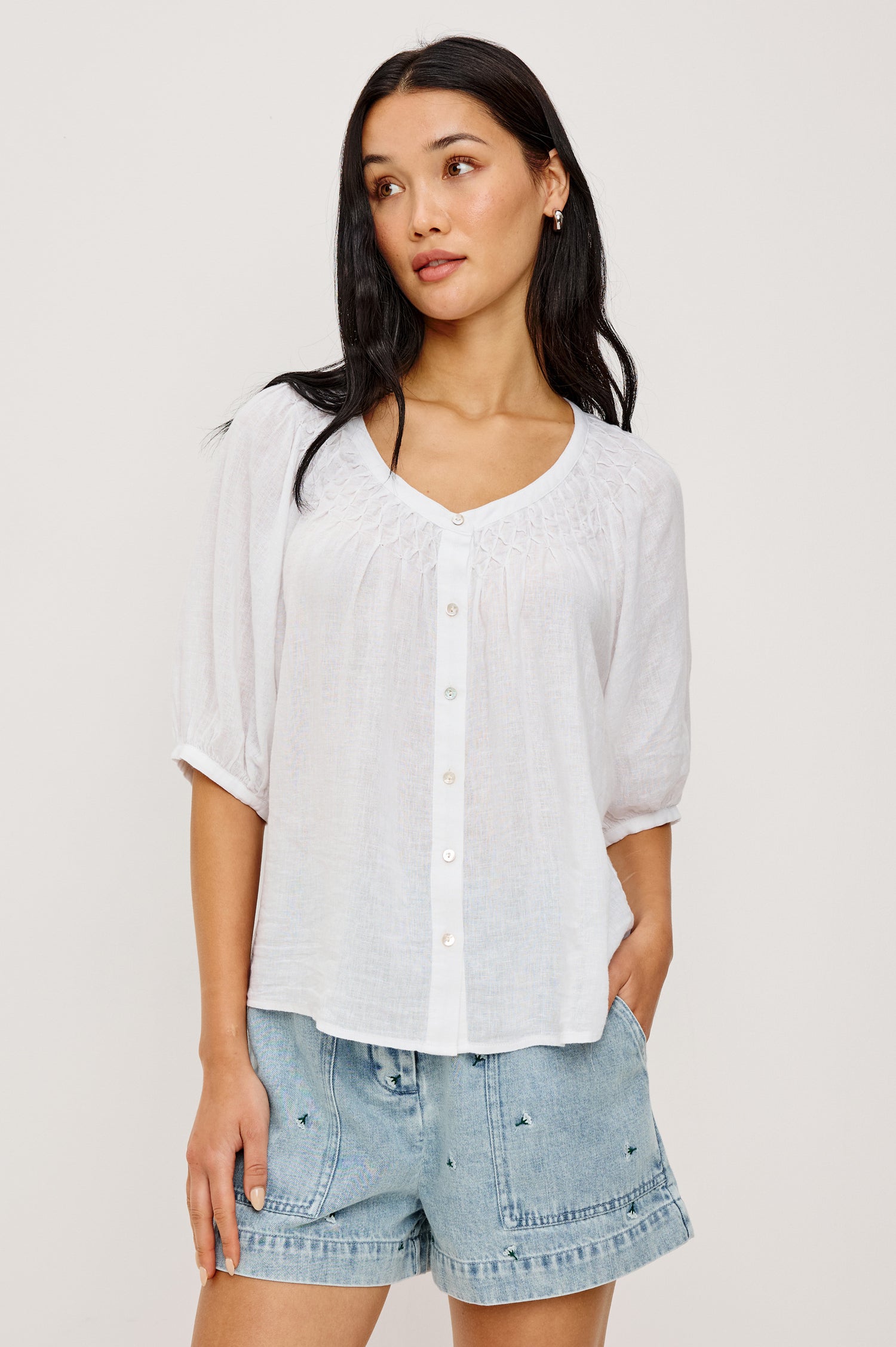 Rix Relaxed Button-Up Top in Linen With Scoop Neckline, Smocked Yoke, and Elbow Length Raglan Sleeves in White Colorway - Upper Body Front View Featured on Model