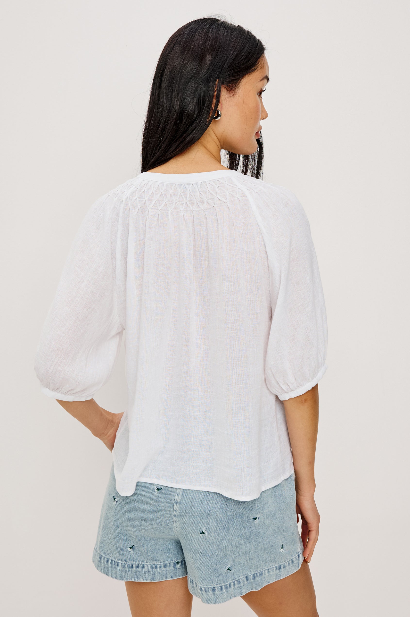 Rix Relaxed Button-Up Top in Linen With Scoop Neckline, Smocked Yoke, and Elbow Length Raglan Sleeves in White Colorway - Upper Body Back View Featured on Model