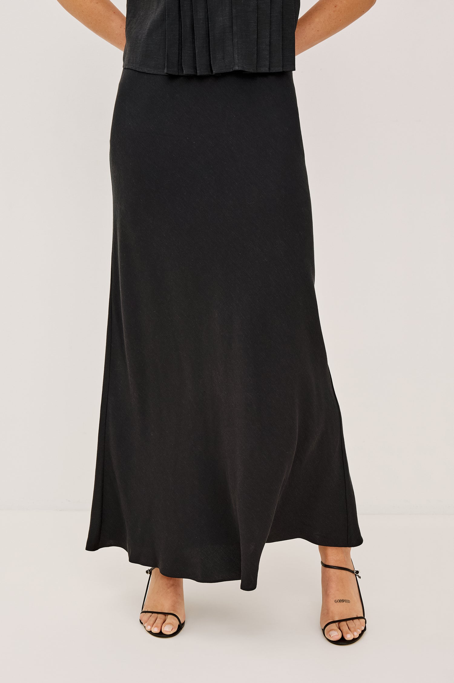 Romina Maxi Skirt in Luxe Linen With High-Waisted Fit and Elastic Waistband in Black Linen Colorway - Lower Body Front View Featured on Model
