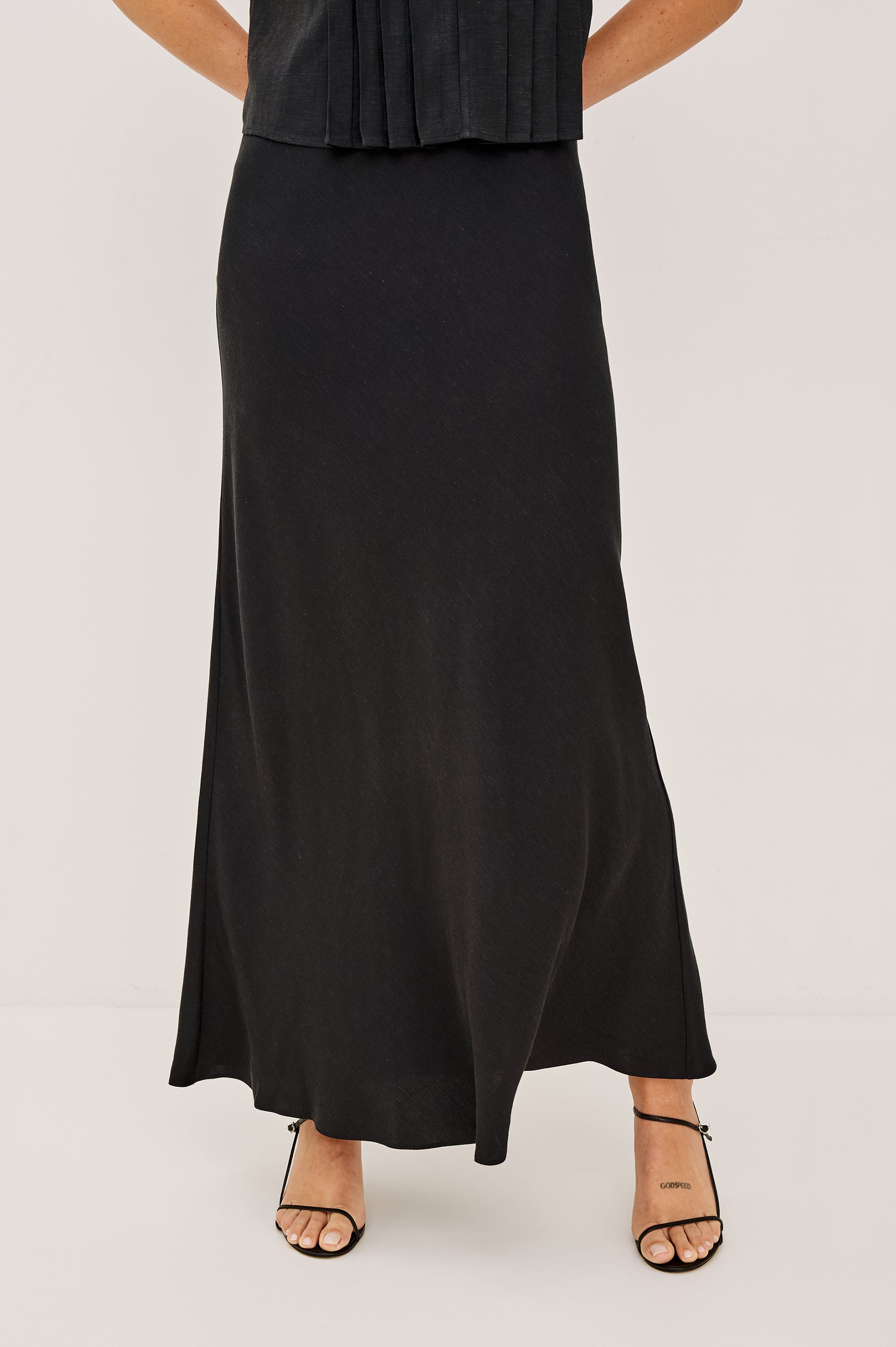 Romina Maxi Skirt in Luxe Linen With High-Waisted Fit and Elastic Waistband in Black Linen Colorway - Lower Body Front View Featured on Model