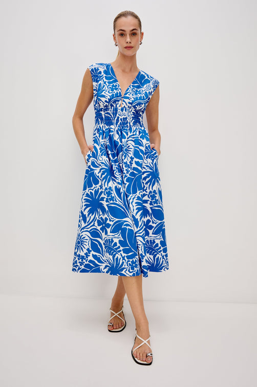 Roxanne A-Line Midi Dress with Smocked Waist, V-Neck, Cap Sleeve and Side Pockets in Blue Riviera Colorway. Full Body Front View Shown on Model.