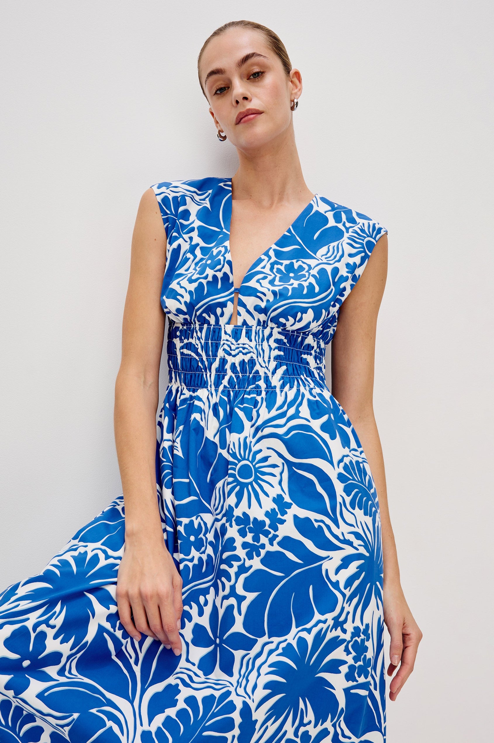 Roxanne A-Line Midi Dress with Smocked Waist, V-Neck, Cap Sleeve and Side Pockets in Blue Riviera Colorway. Front View Shown on Model.