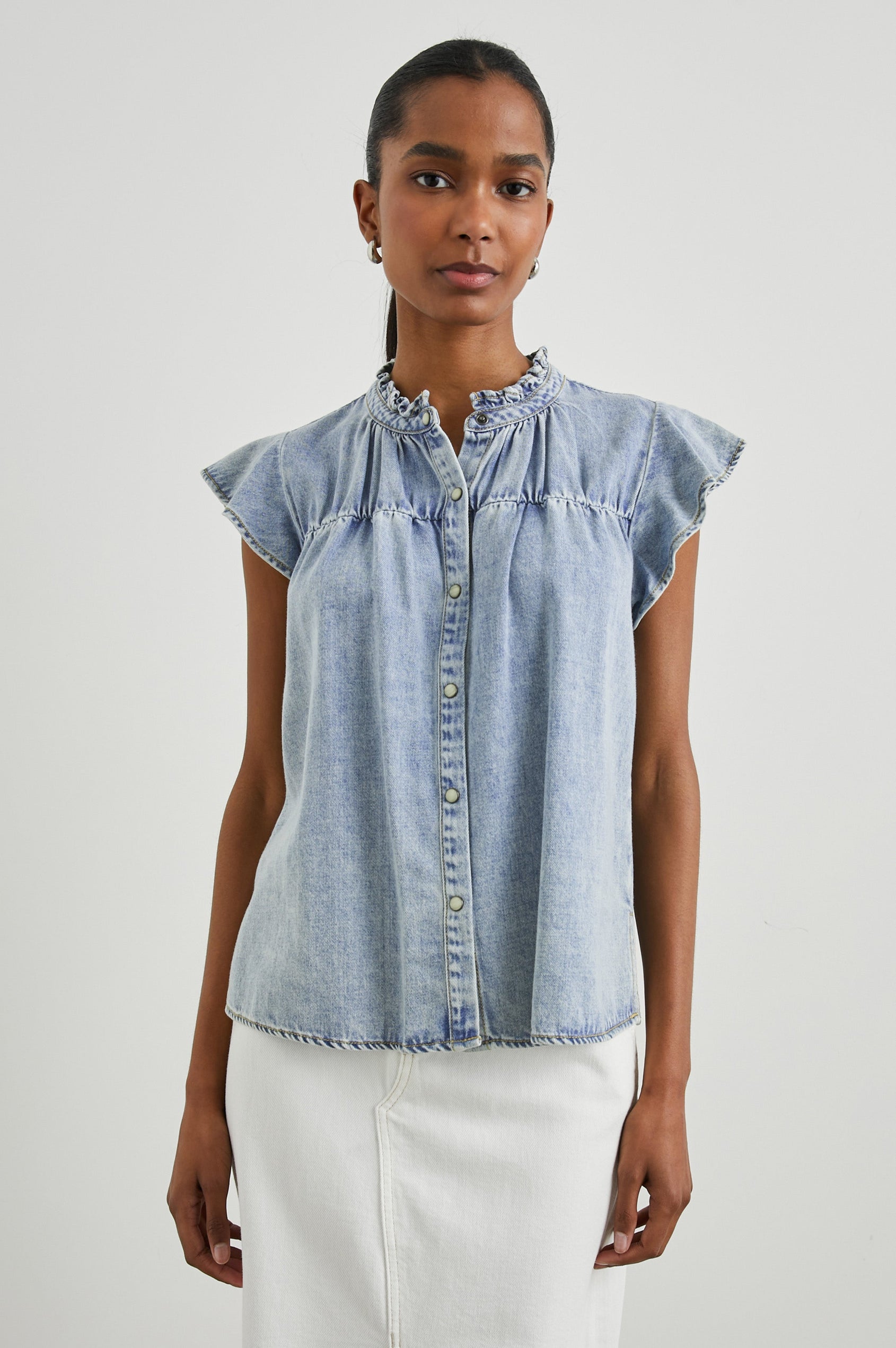 Ruthie Top with Flutter Cap Sleeves, a Ruffled Banded Collar, Buttons Down the Front, and Soft Shirring at Front Yoke in Faded Indigo Colorway - Front  View Featured on Model