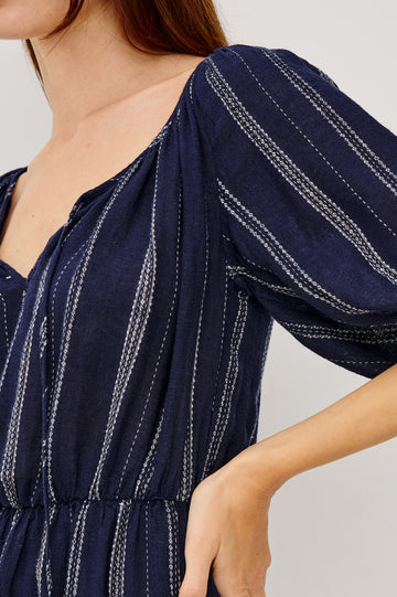 Saba Linen Mini Dress With Scoop Neckline Center-Front Ties Elbow-Length Puff Sleeves in Marina Stripe Colorway - Upper Body Side View Featured on Model