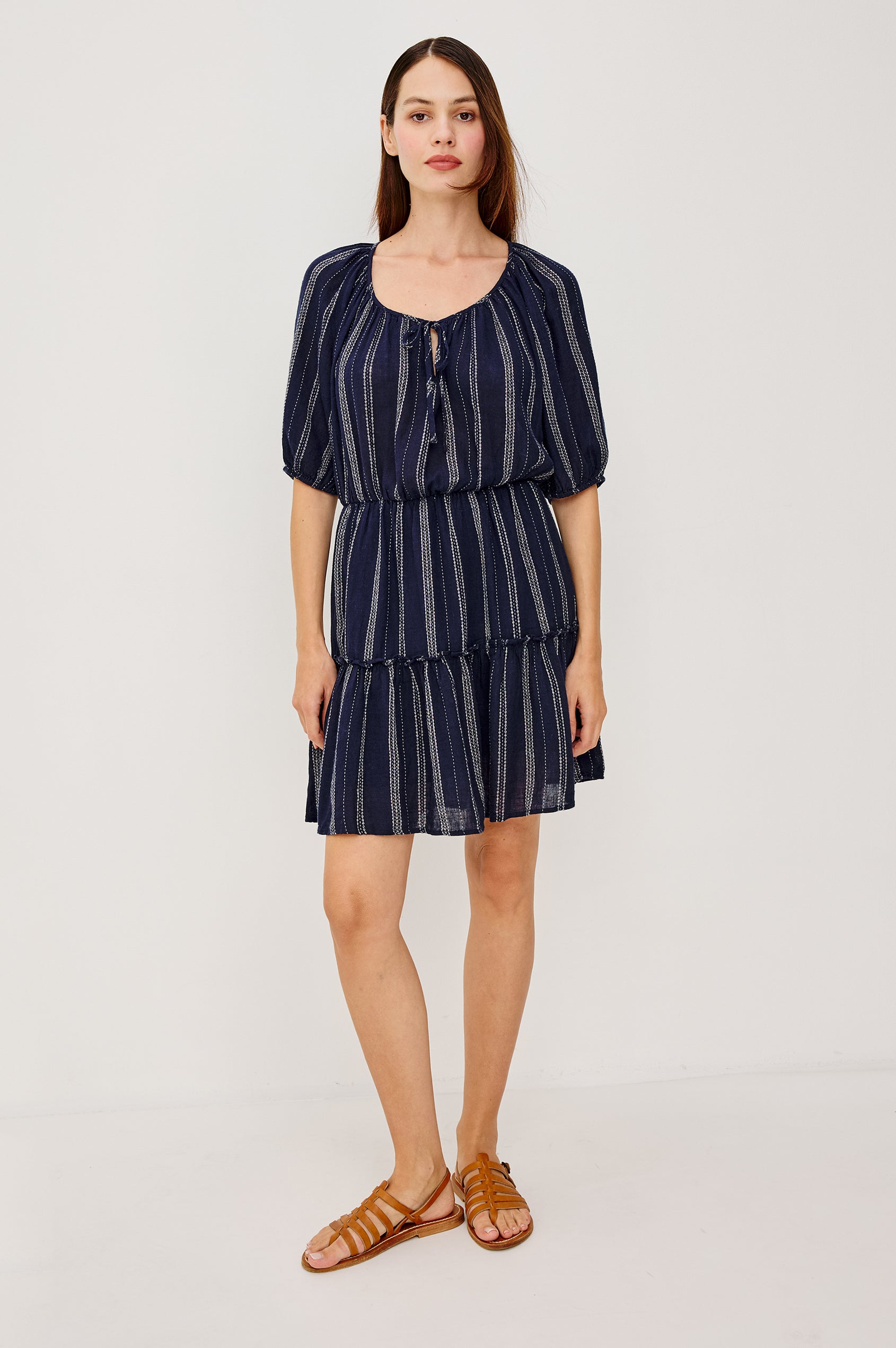 Saba Linen Mini Dress With Scoop Neckline Center-Front Ties Elbow-Length Puff Sleeves in Marina Stripe Colorway - Upper Body Front View Featured on Model Walking