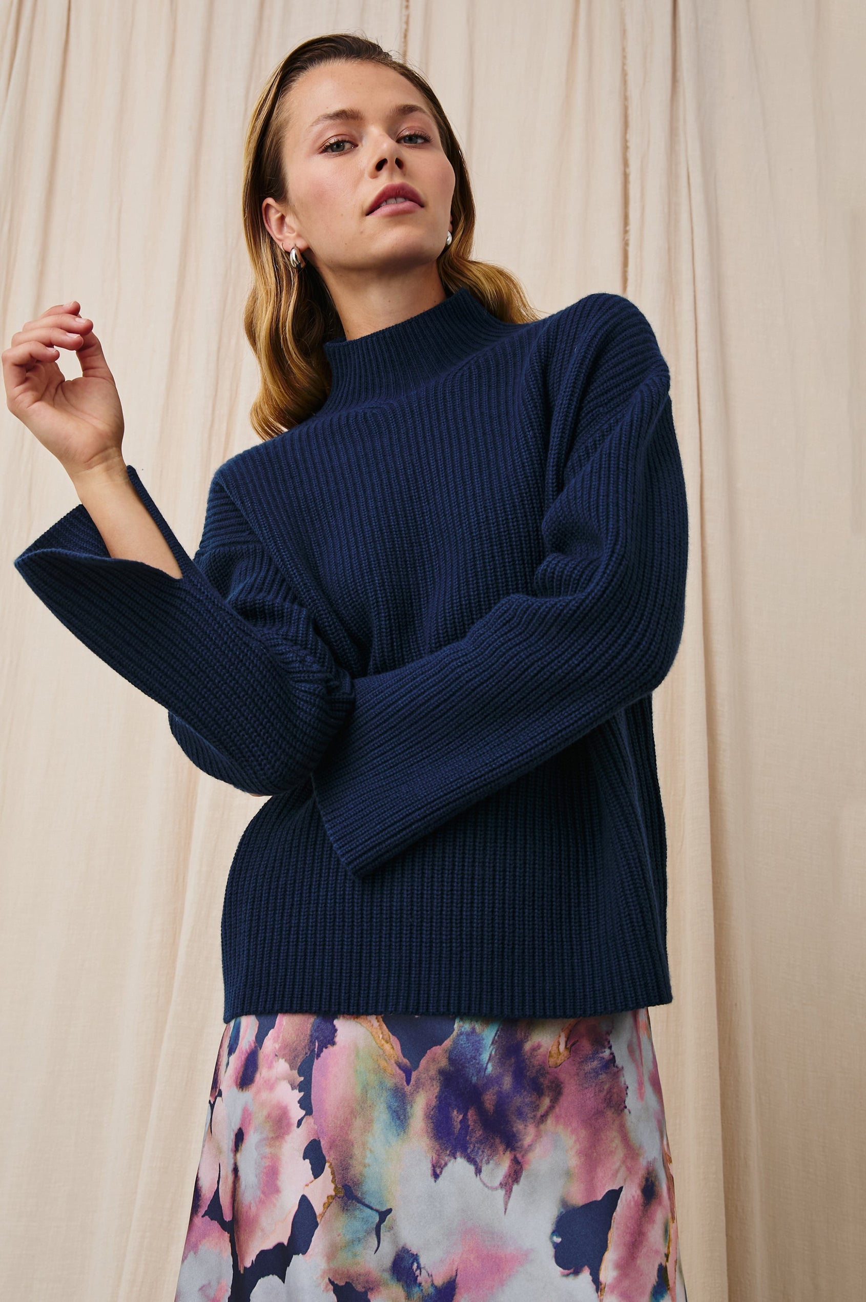 Sanna Long Sleeve Knit Sweater with a Funnel Neck and Slits at the Back of the Neck and on the Cuffs in Dark Slate Colorway - Front View Featured on Model