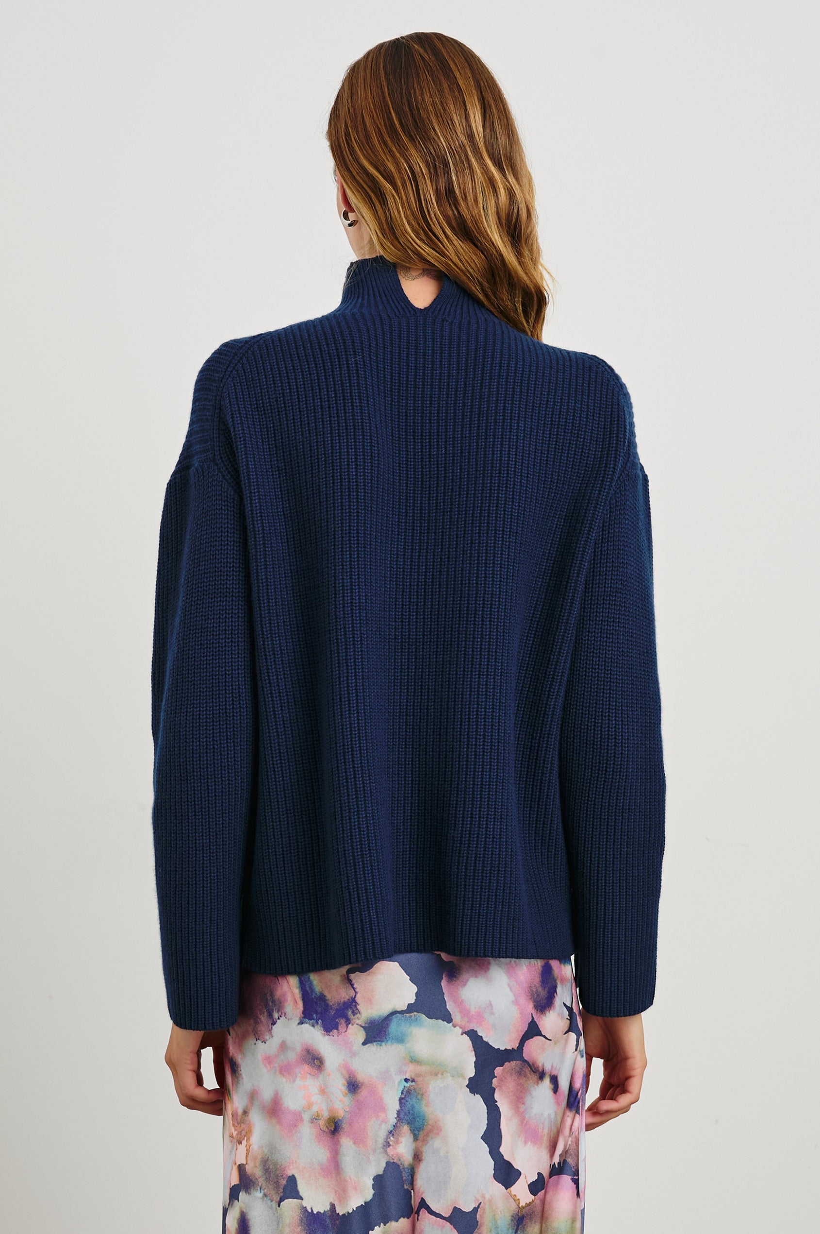 Sanna Long Sleeve Knit Sweater with a Funnel Neck and Slits at the Back of the Neck and on the Cuffs in Dark Slate Colorway - Back View Featured on Model