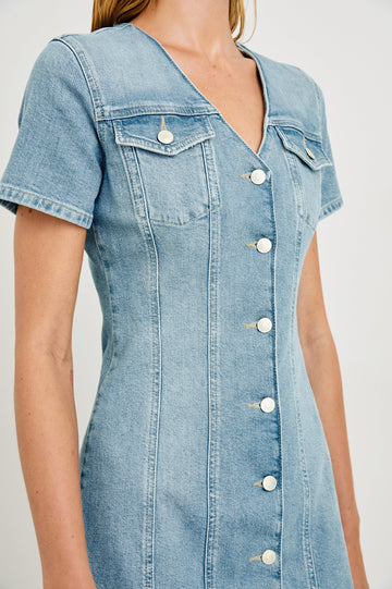Saratoga a-line mini button down denim dress with two front chest pockets. Short sleeve and form fitting in Faded Seaglass - close up of details on model