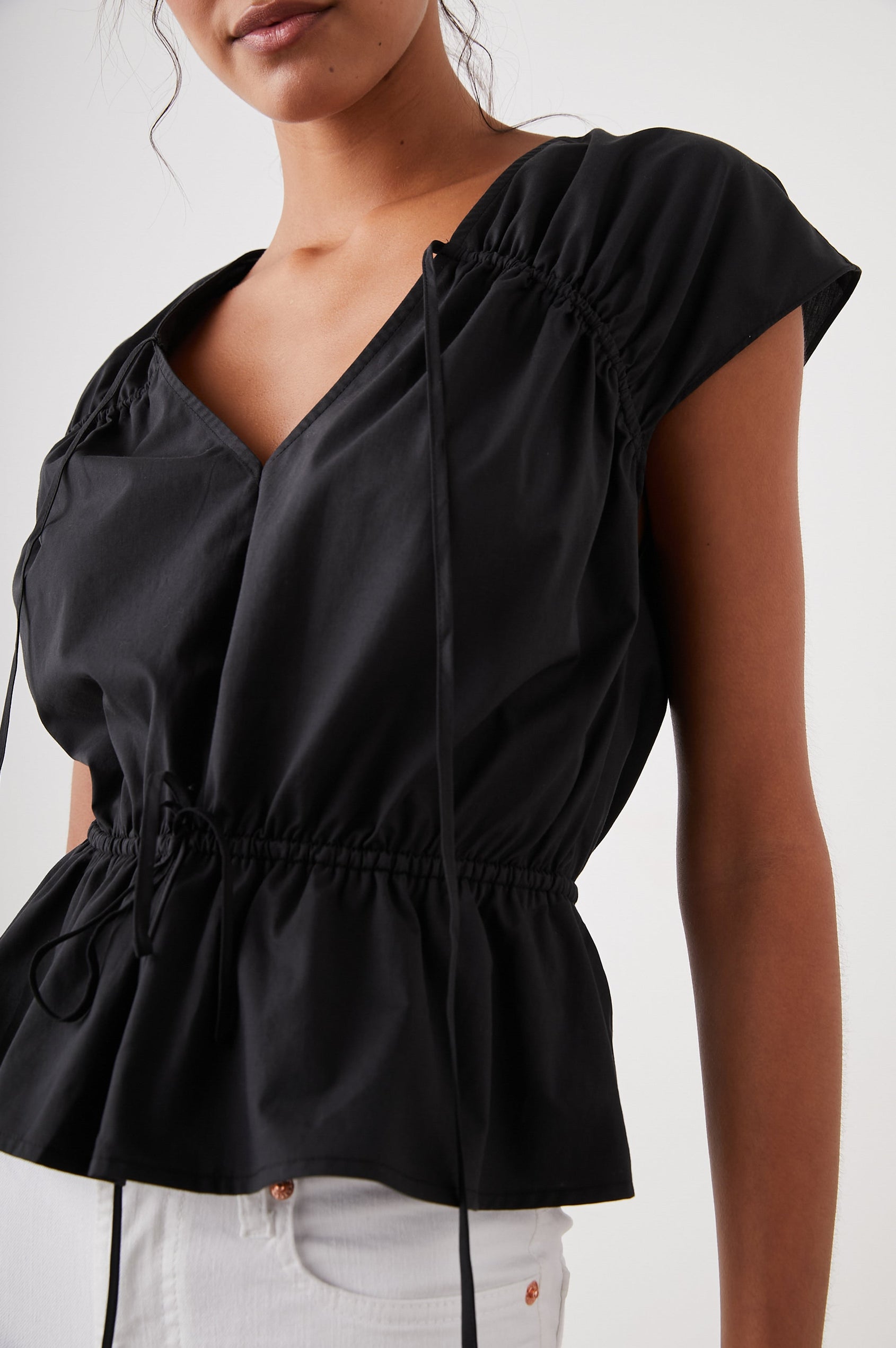 Savi Short-Sleeve Top with a V Neck, Cap Sleeves, a Drawstring From Each Sleeve Shoulder to the Neckline and a Drawstring at the Waist in Black Colorway - Front View Featured on Model 