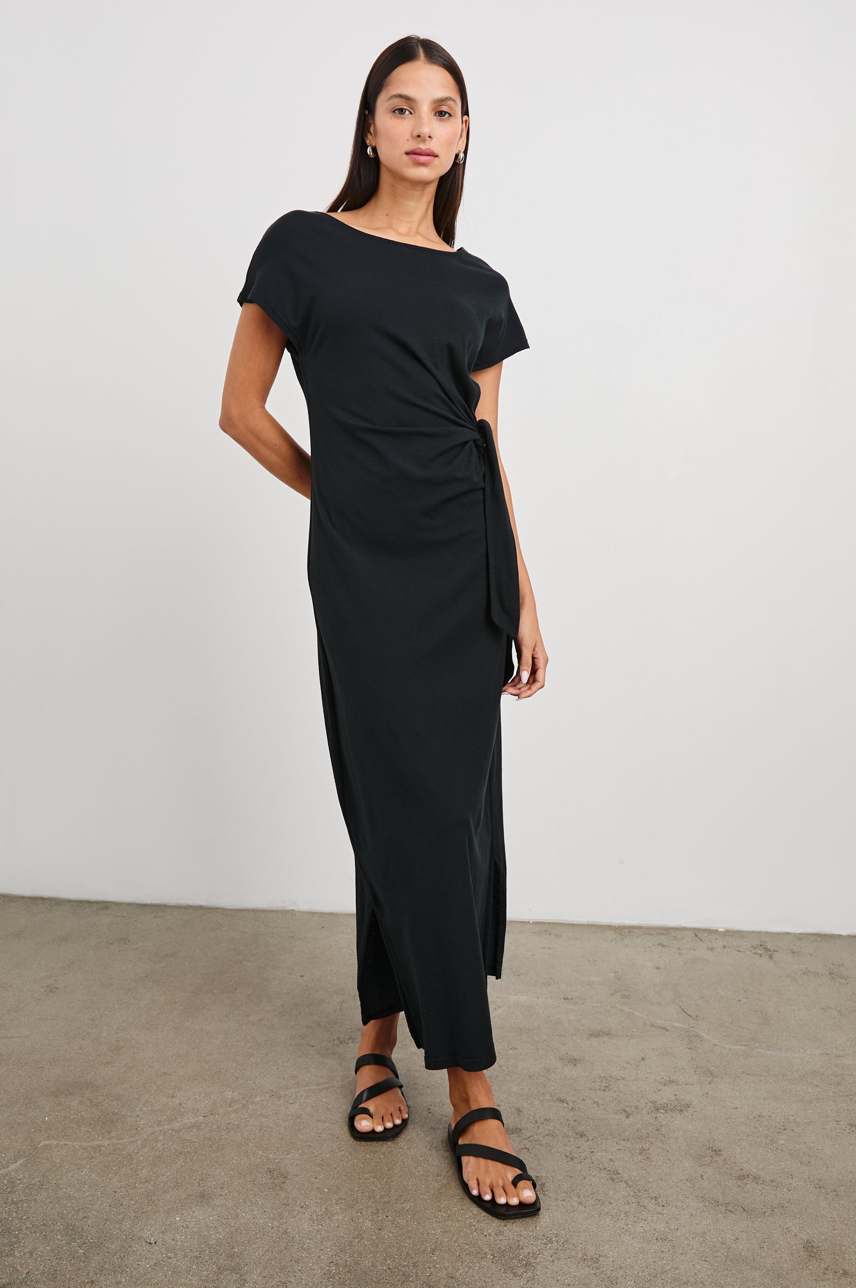 Selah Maxi Dress with Short Sleeves, Boatneck, Adjustable Side Tie at Waist and Two Mid-Calf Side Slits in Black Colorway  - Front Full Body View Featured on Model