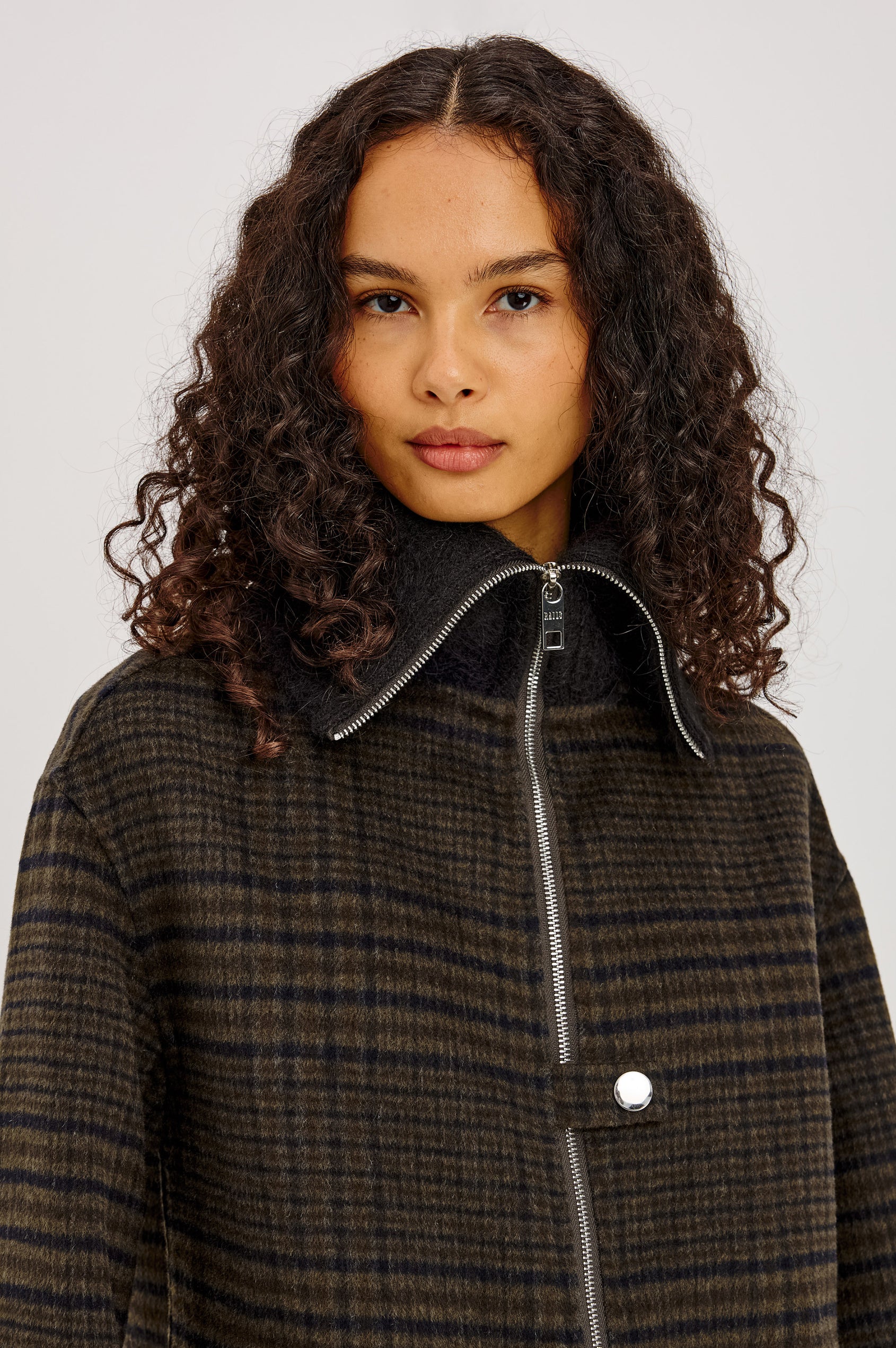 Silves Jacket in Heavy Wool Blend With Contrast Brushed Shawl Collar, Two-Way Front Zip, Single Snap Button, Long Sleeves, and Side Pockets in Highland Plaid Colorway - Upper Body Front View Featured on Model