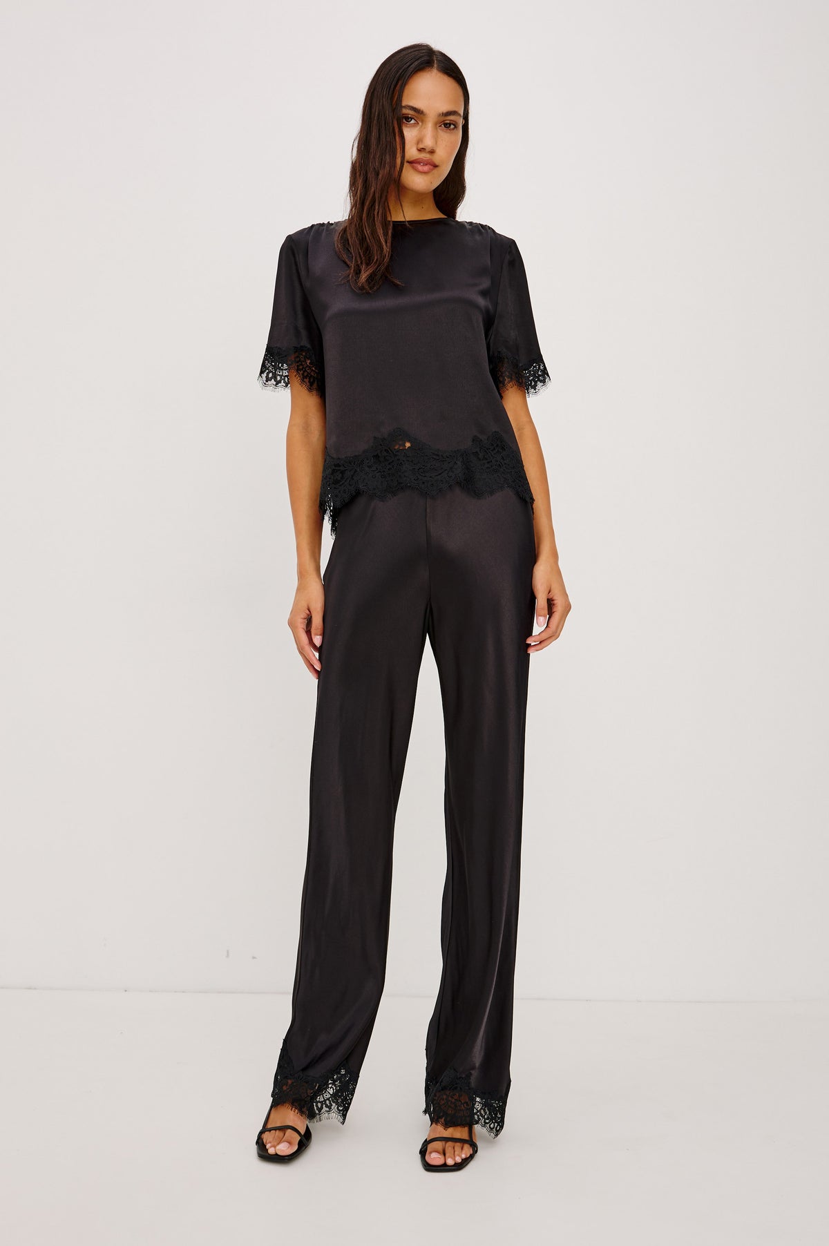 Silvi Pant in Satin-Back Crepe With Straight Legs, Elastic Waist, and Lace Hem in Black Colorway - Front Full Body View Featured on Model.