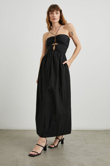 Silvia Sleeveless Maxi Dress with Spaghetti Straps with a Lower Back Tie, an Open Back, and Cutouts Along the Center of the Bodice in Black Nylon Colorway - Front Full Body View Featured on Model