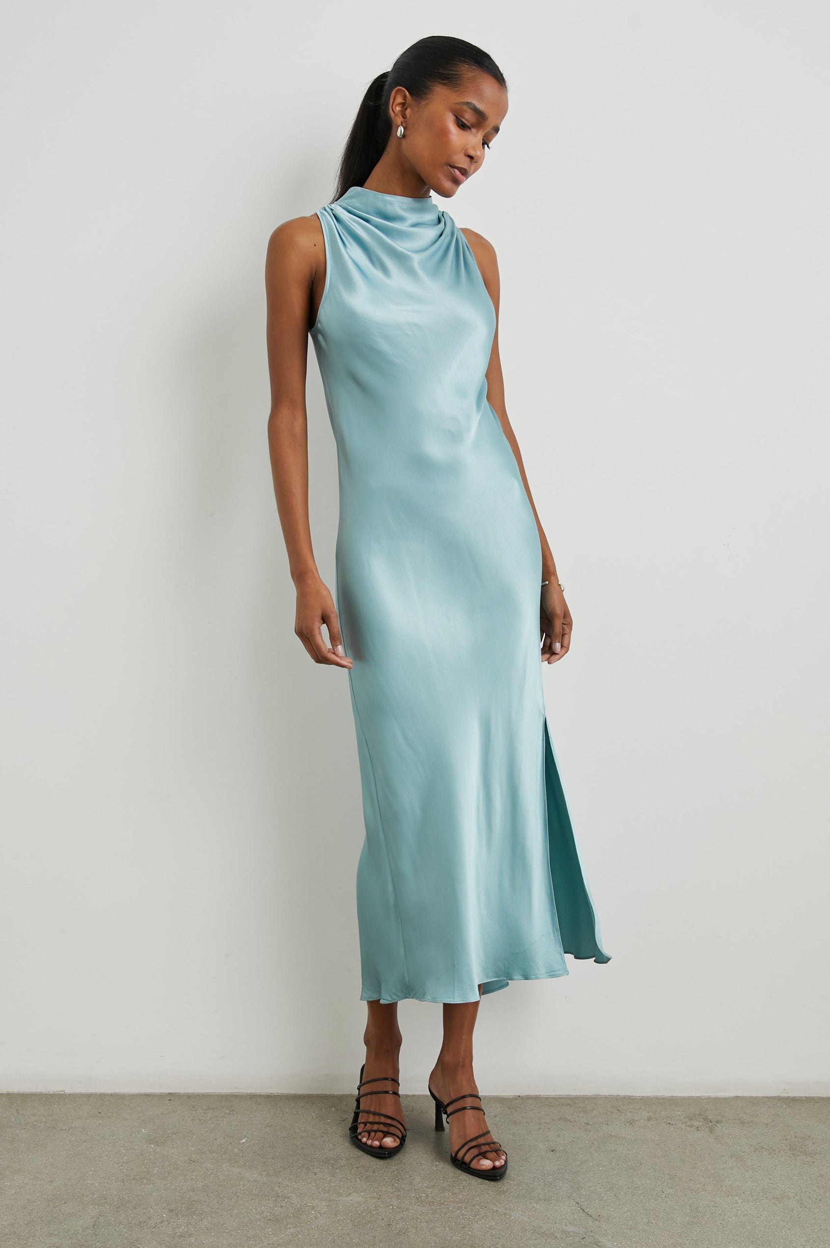 Solana Sleeveless Midi Dress with a High Cowl Collar, Side Slit, and Two Button Keyhole Closure at the Back in Clearwater Colorway, a Blue - Front Full Body View Featured on Model