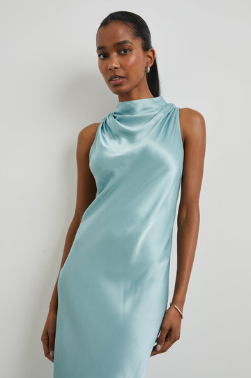 Solana Sleeveless Midi Dress with a High Cowl Collar, Side Slit, and Two Button Keyhole Closure at the Back in Clearwater Colorway, a Blue - Front View Featured on Model