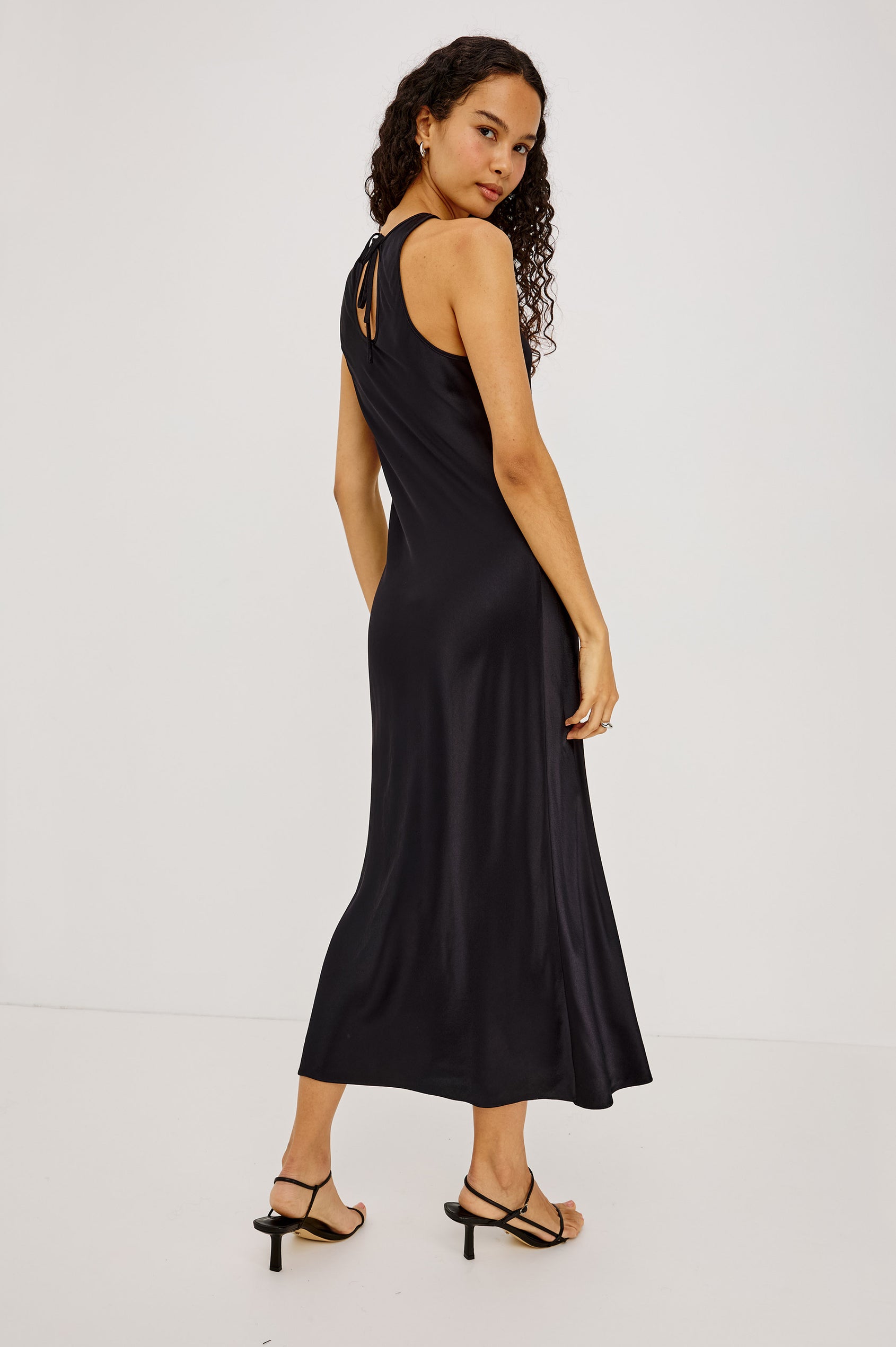Solene Midi Dress in Satin-Back Crepe With Jewel Neck, and Back Keyhole With Self-Tie in Black Colorway - Full Body Back View Featured on Model